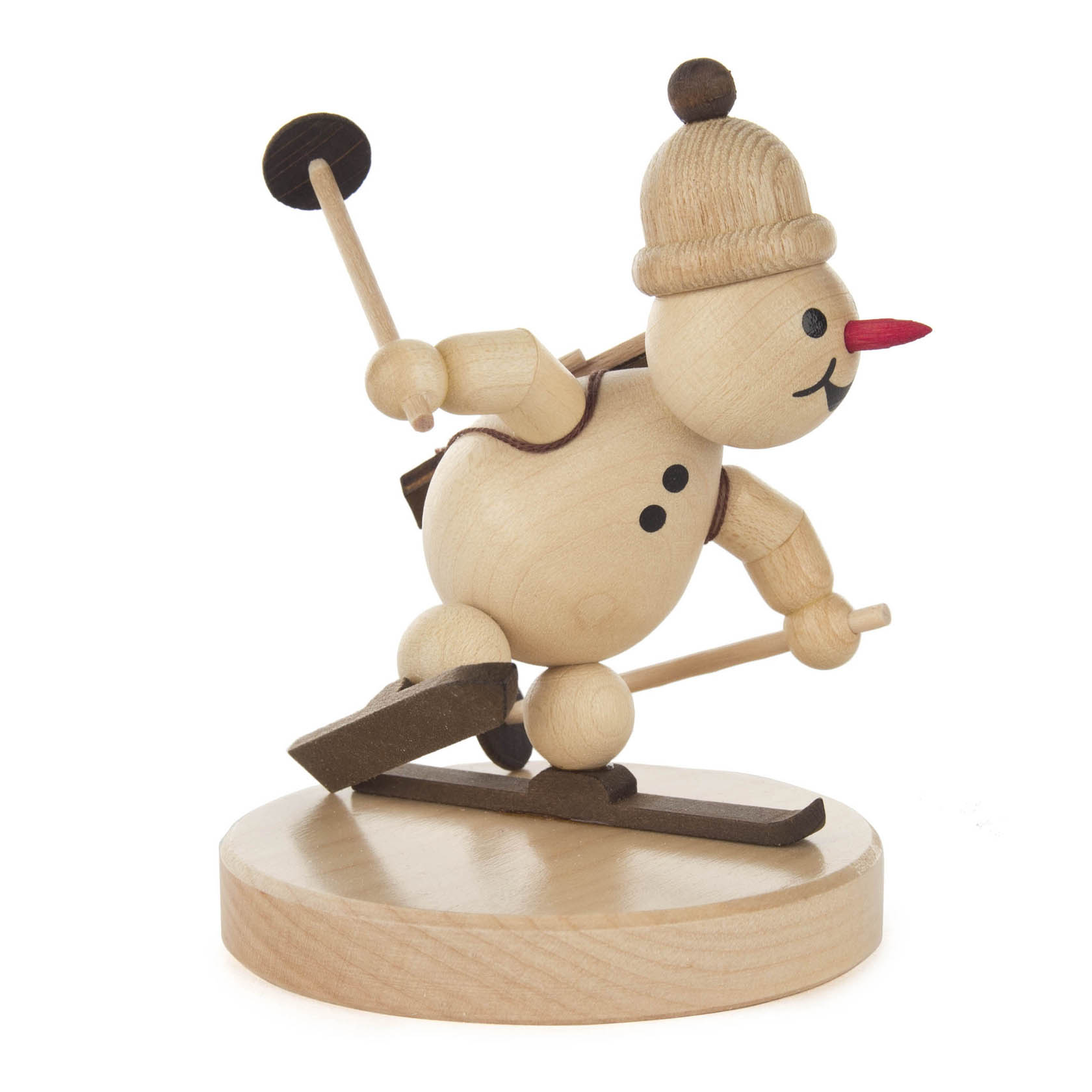 Holzfigur eines Schneemanns mit Mütze, auf Skiern im Biathlon-Stil, mit Stöcken und Gewehr auf dem Rücken.