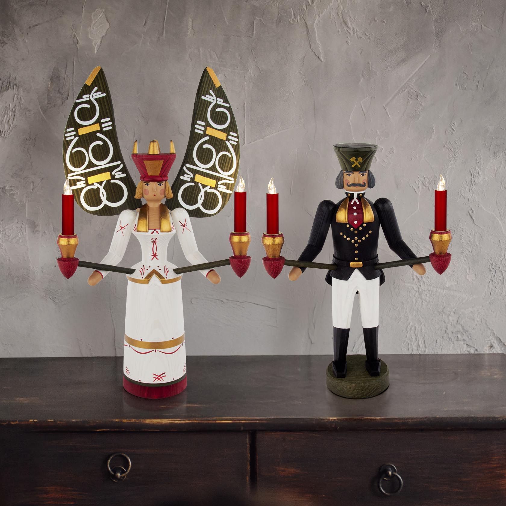 Ein großer, traditioneller Erzgebirgischer Weihnachtsengel mit zwei Kerzen in den Händen, in weißem Kleid und roter Krone.