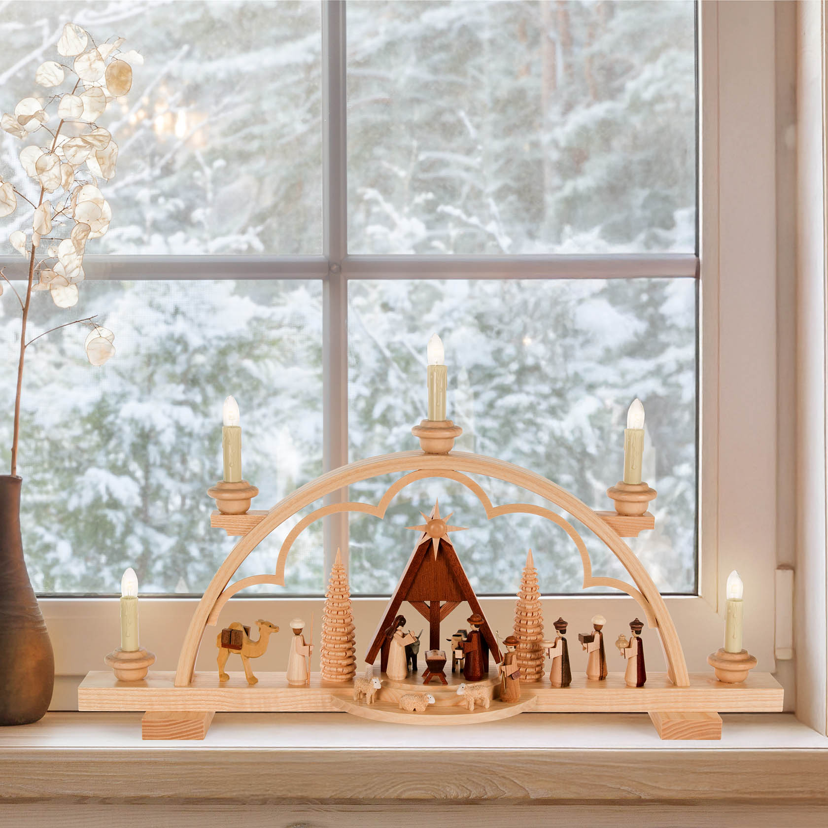 Wooden arch with figures of the Nativity scene, including Mary, Joseph, baby Jesus, shepherds, and wise men, electrically lit.