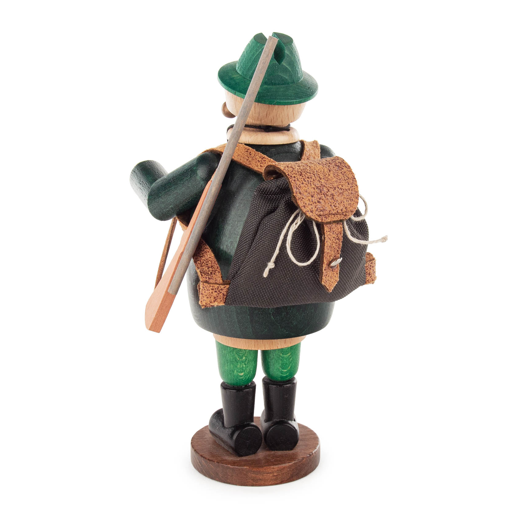 Ein traditioneller Räuchermann in Form eines Försters, mit grünem Hut und Mantel, einem Rucksack und einem Gewehr über der Schulter, auf einem Holzsockel stehend.