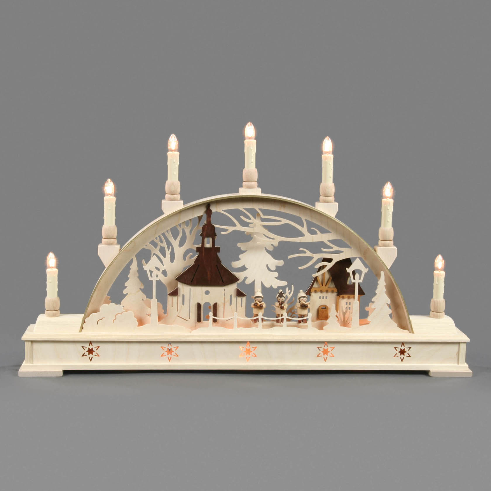Electric illuminated Schwibbogen featuring Seiffener Church and Kurrende singers with several lit candles on top.