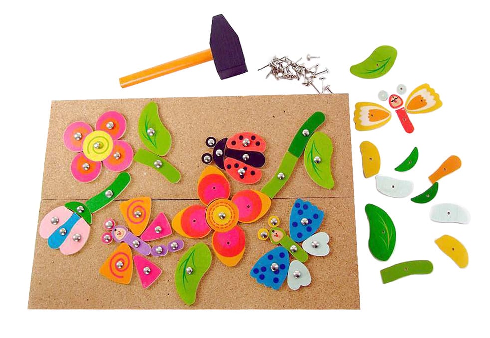 Wooden board with colorful wooden flowers, butterflies, and a ladybug tacked onto it. A small hammer and nails are visible, along with spare wooden pieces. im Dregeno Online Shop günstig kaufen