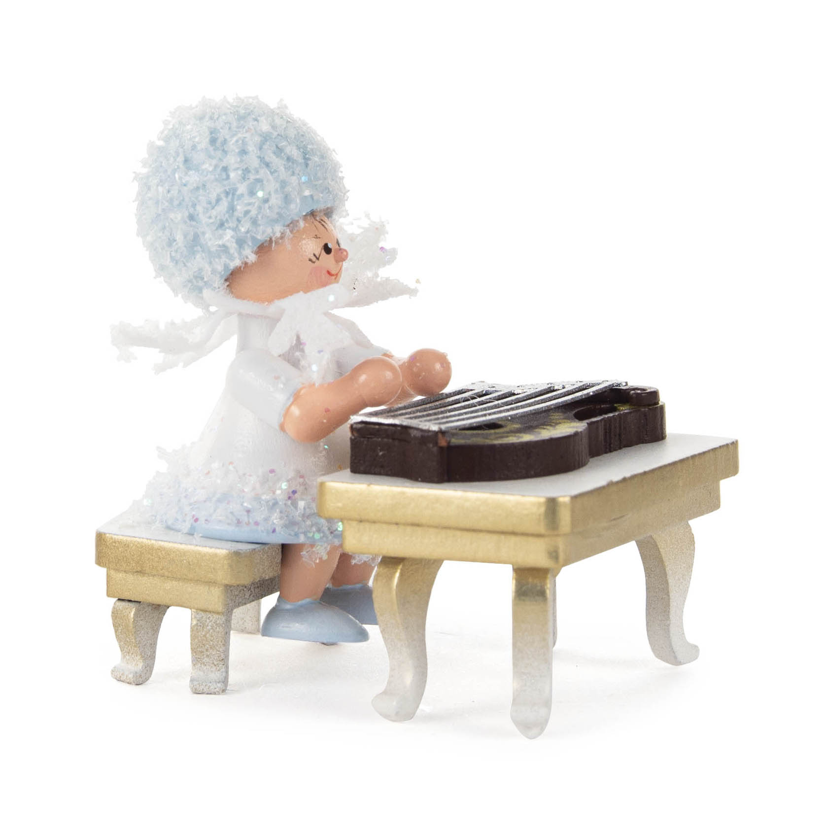 A small figurine of a snowflake fairy sitting on a bench, playing a zither. The fairy has a blue, fluffy hat and is dressed in white. im Dregeno Online Shop günstig kaufen