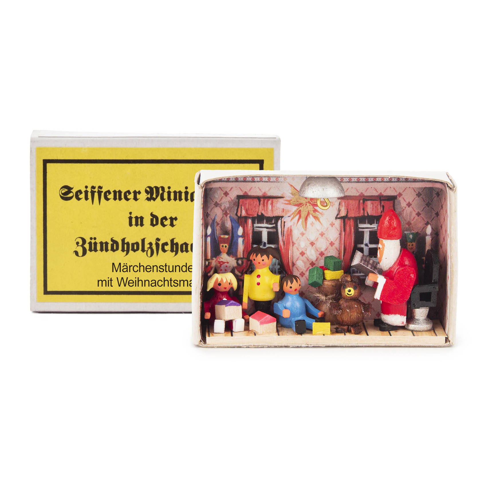 A miniature scene inside a matchbox featuring wooden figures, including Santa Claus, children, a bear, and Christmas gifts. im Dregeno Online Shop günstig kaufen