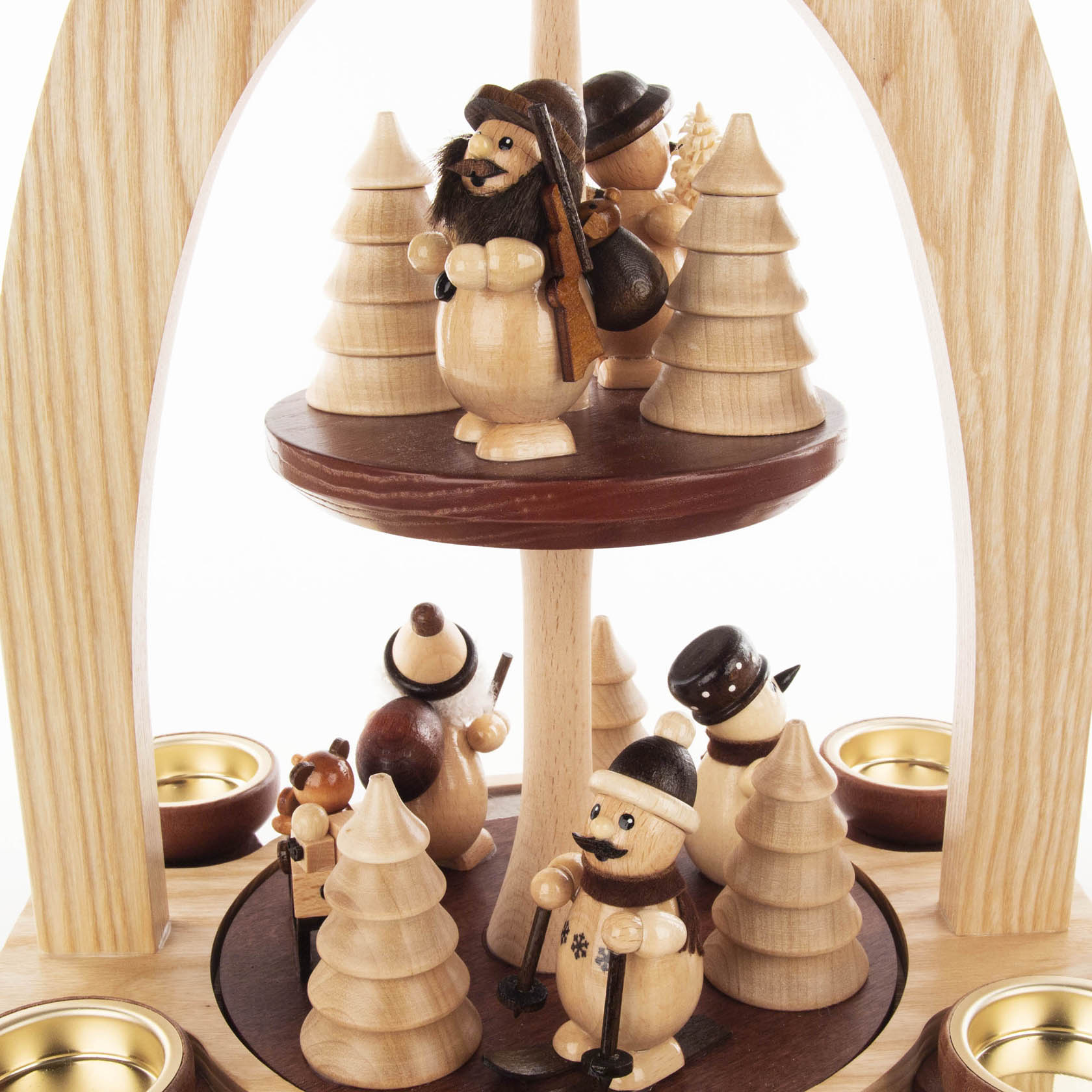 A two-tiered wooden pyramid featuring handcrafted wooden figures, including a Santa Claus and snowmen, surrounded by small wooden trees, designed for tealights.