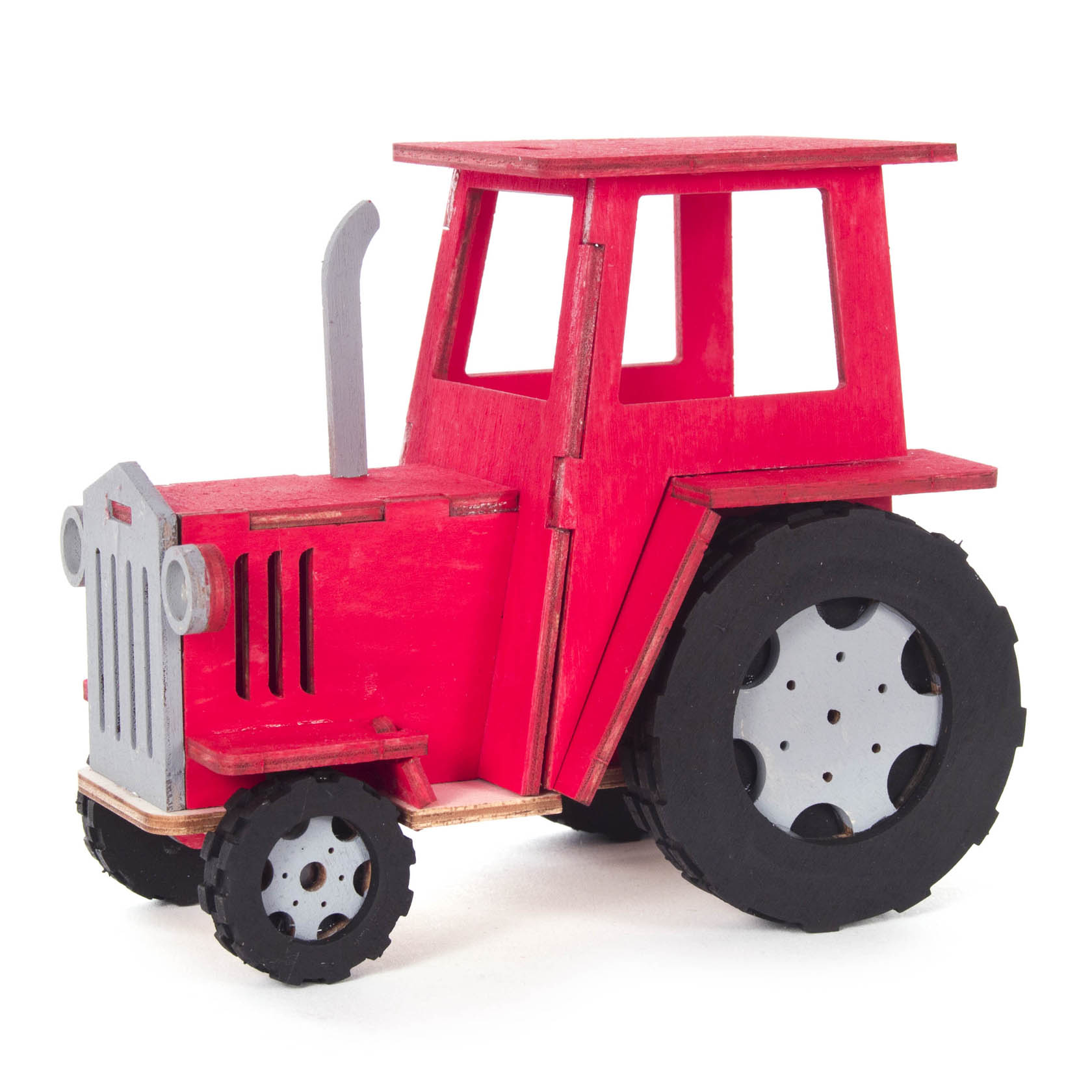 Red wooden tractor model with black tires and a gray exhaust pipe, on a rectangular base.