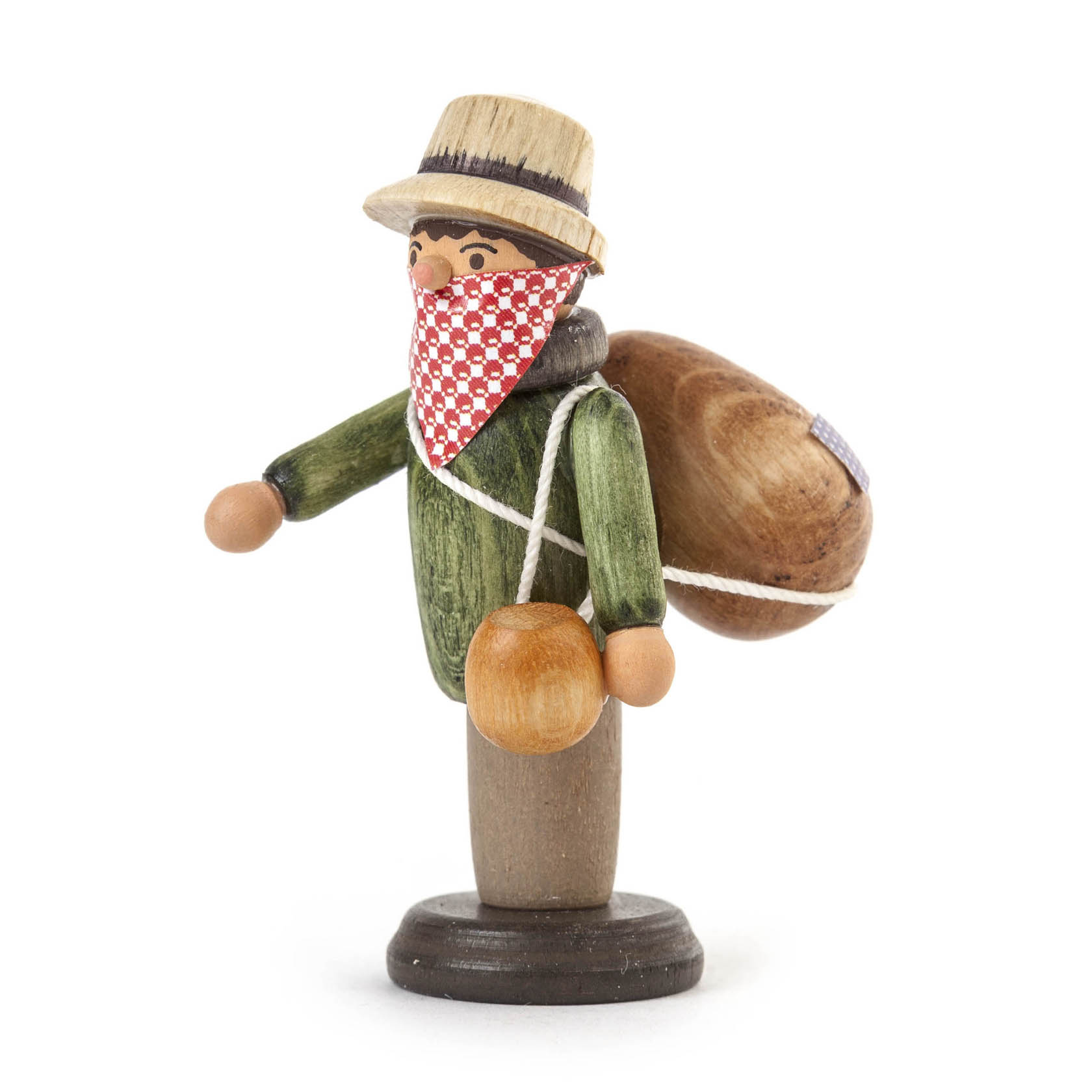 Wooden figurine of a peddler with a green coat, red and white bandana covering mouth, hat, brown sack on back, and small wooden jug.
