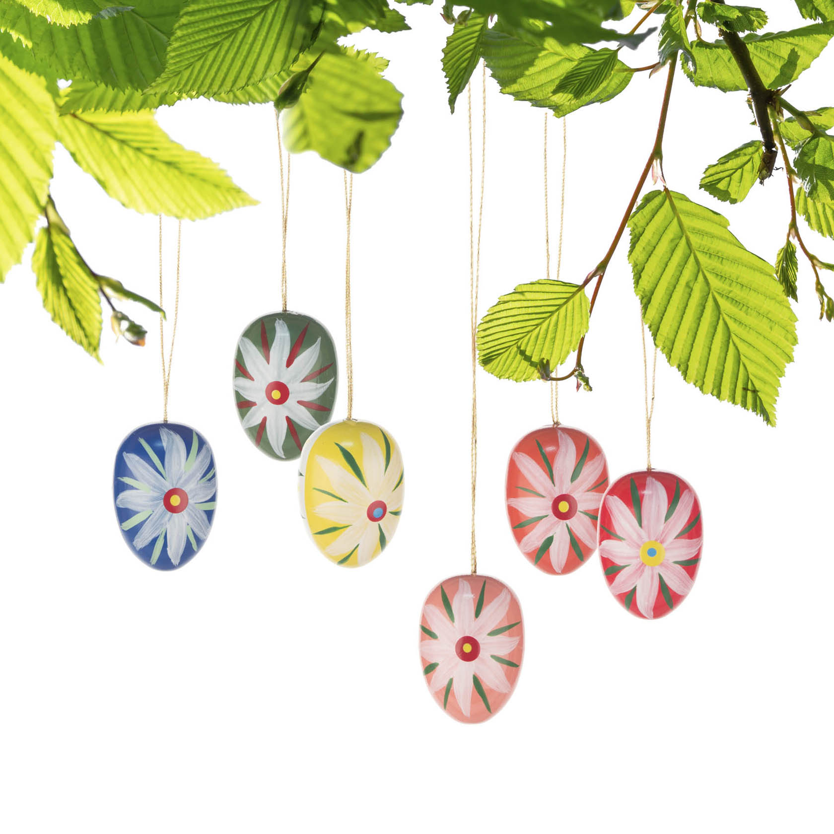 Six colorful Easter eggs with flower patterns hanging from branches with green leaves.