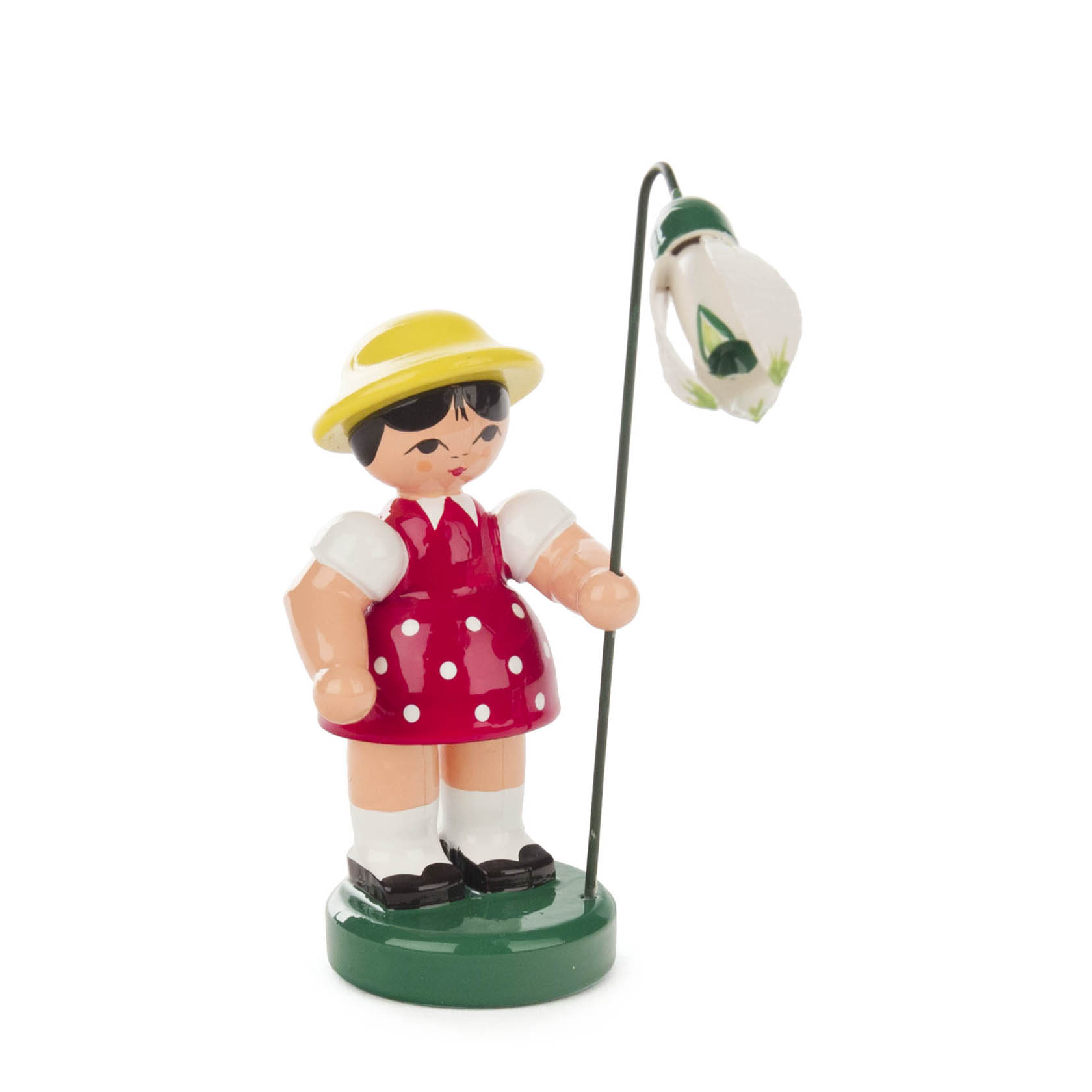 A wooden figurine of a girl in a red dress with white polka dots, wearing a yellow hat, holding a white flower on a long stick. im Dregeno Online Shop günstig kaufen
