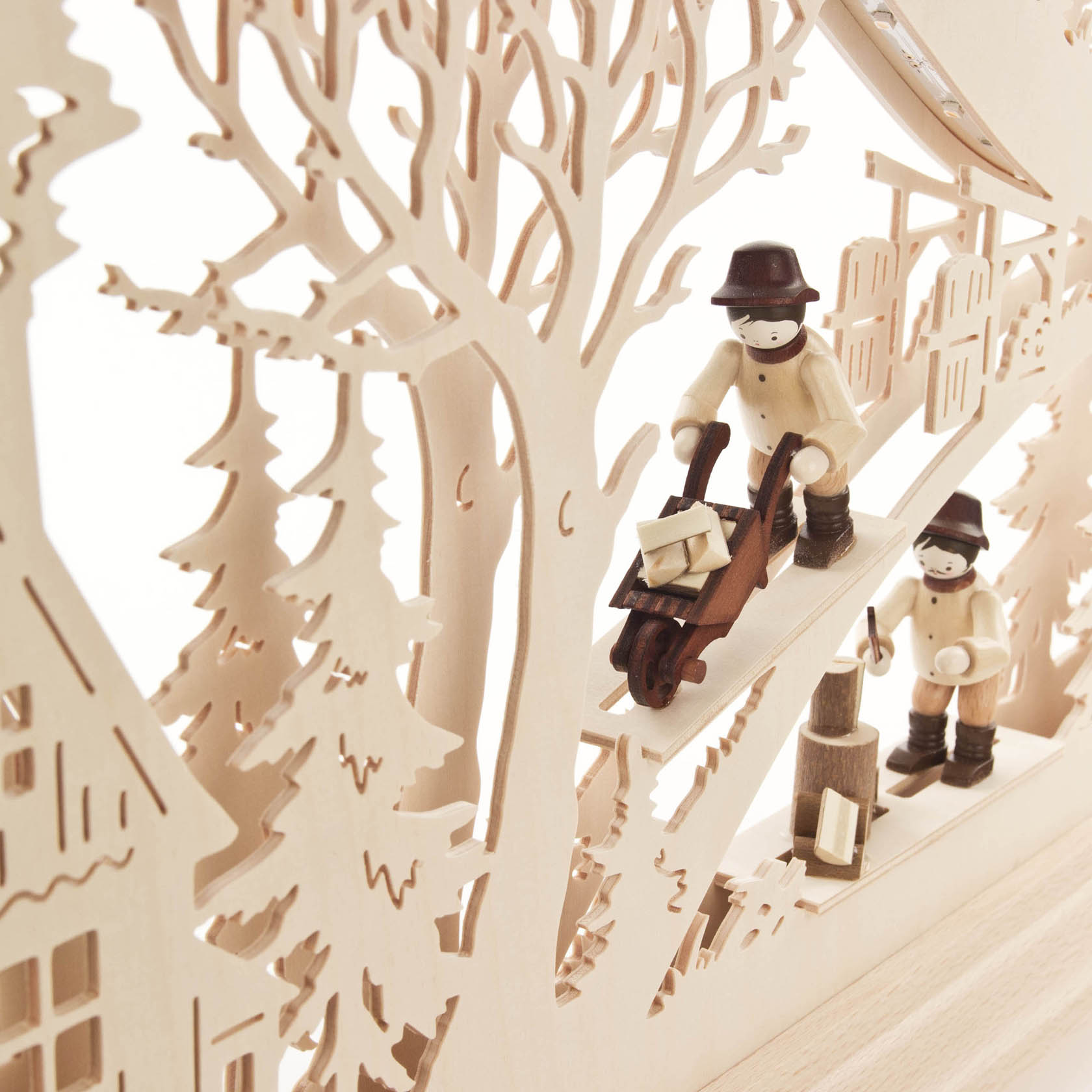 A wooden arch with a forest hut and two figures. One is a woodworker pushing a wheelbarrow and the other is chopping wood. LED lights illuminate the scene.