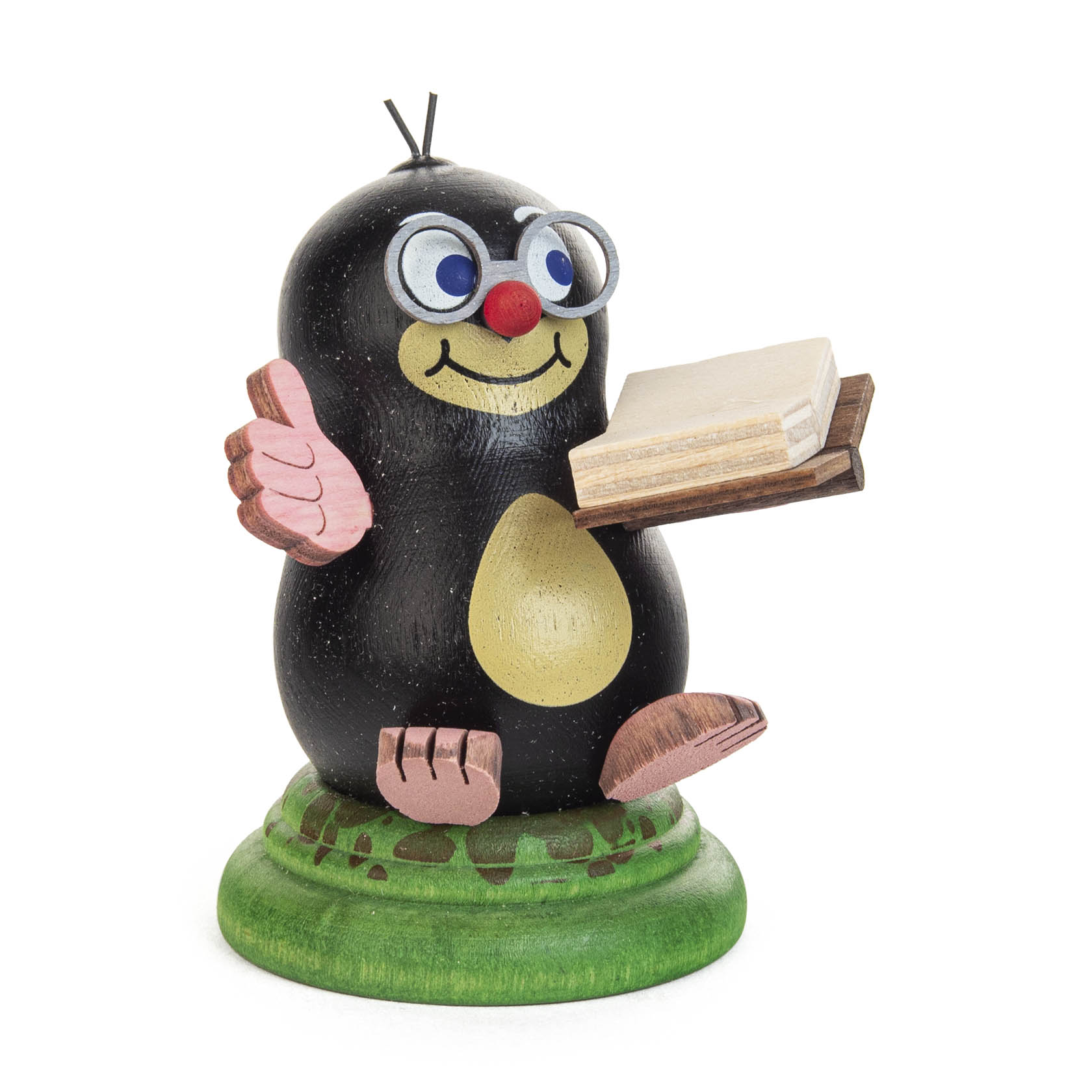 Holzfigur eines lächelnden Maulwurfs mit einer Brille, rosa Nase, hebt die linke Hand und hält ein aufgeschlagenes Buch. Steht auf einem grünen Sockel. im Dregeno Online Shop günstig kaufen