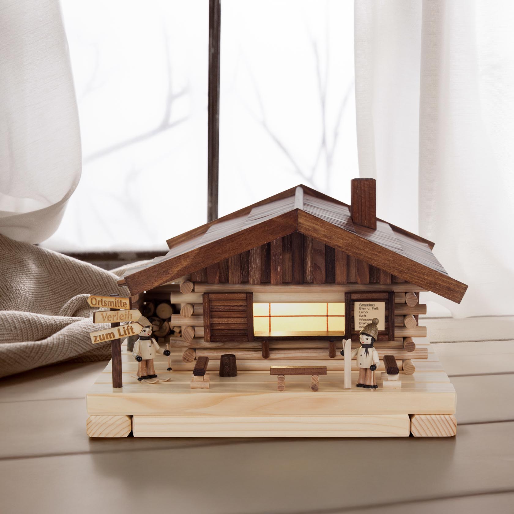Wooden ski lodge incense house with two miniature skiers in traditional attire, featuring electric lighting.