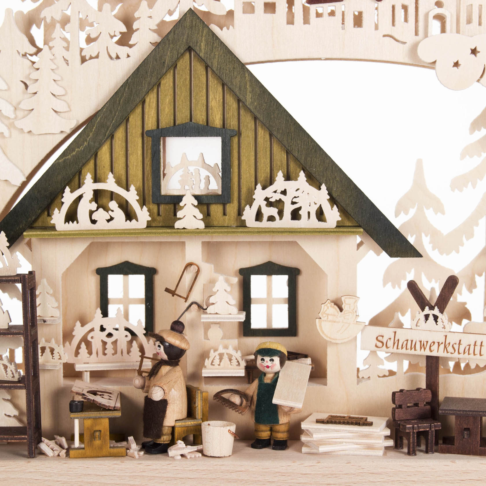 Wooden arch display with craftsmen making Schwibbogen, showcasing intricate details and indirect electric lighting.