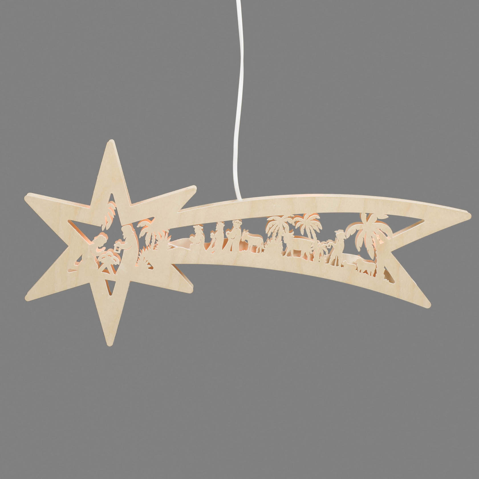 A wooden shooting star decoration with a carved Nativity scene, featuring Mary, Joseph, and baby Jesus, illuminated by electric light.