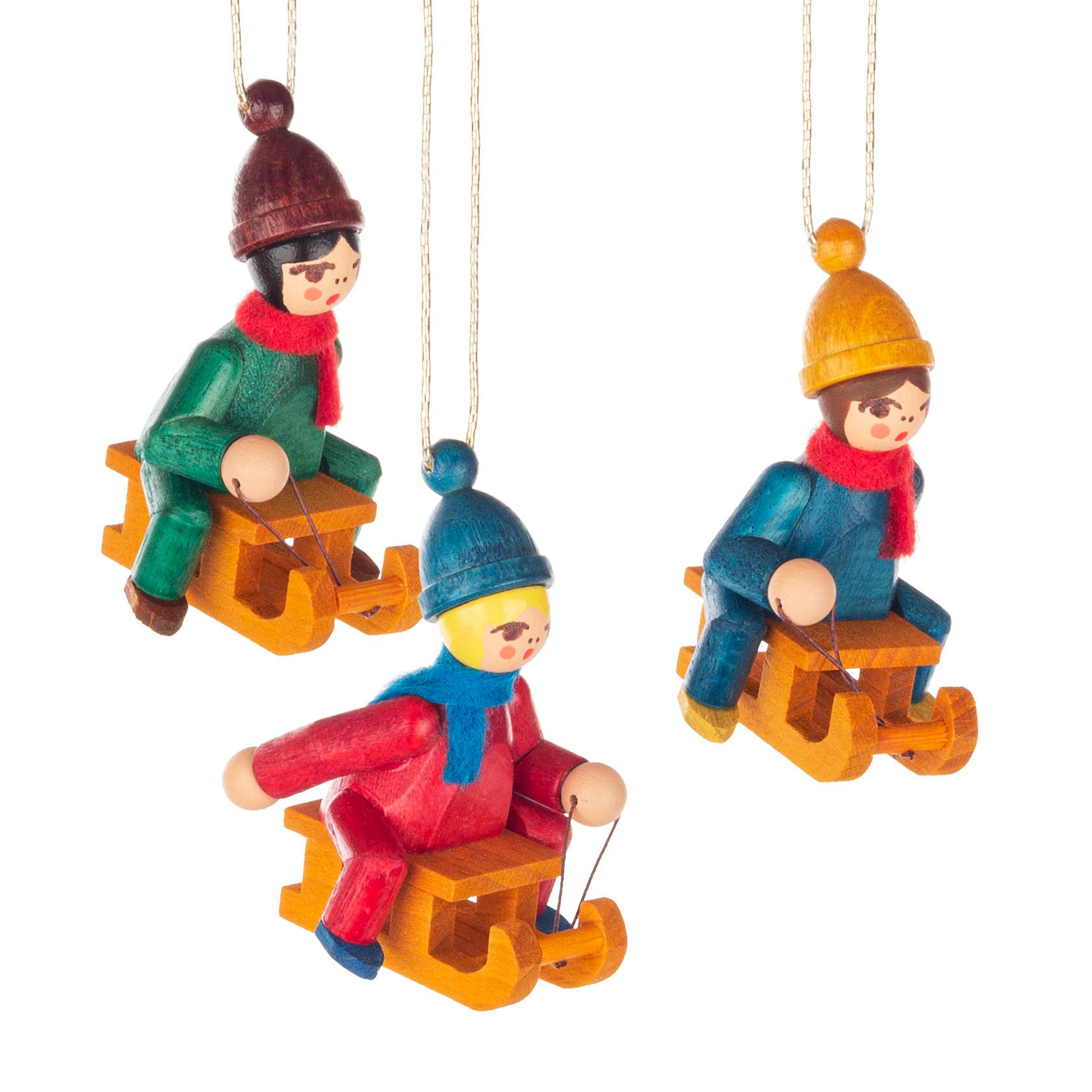 Three colorful figurines wearing winter clothing, each sitting on a wooden sled with strings, designed as tree ornaments. im Dregeno Online Shop günstig kaufen