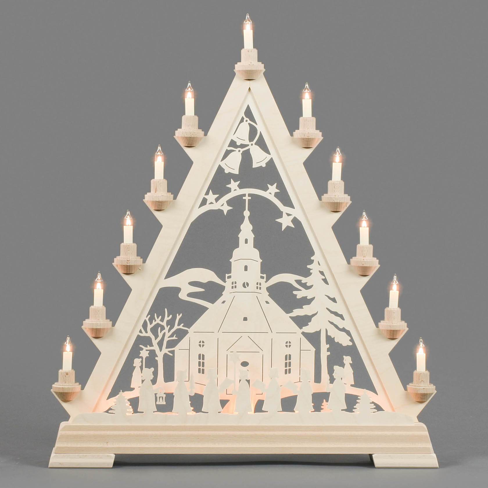 Wooden Christmas triangle featuring the Seiffen church with a Kurrende choir in front, electrically illuminated with candles on its edges.
