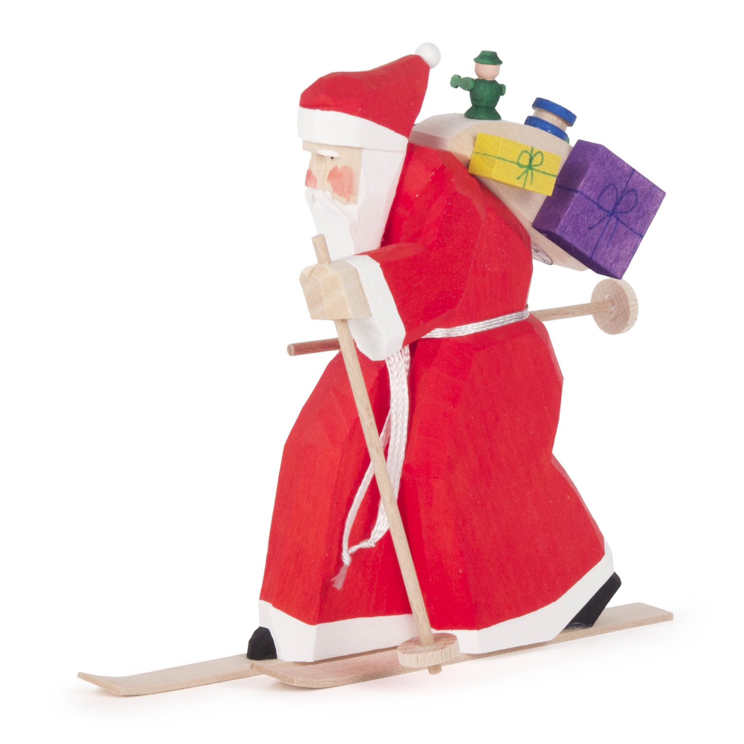 Carved wooden figure of Santa Claus on skis, wearing a red suit and holding a ski stick, with a sack of colorful gifts on his back.