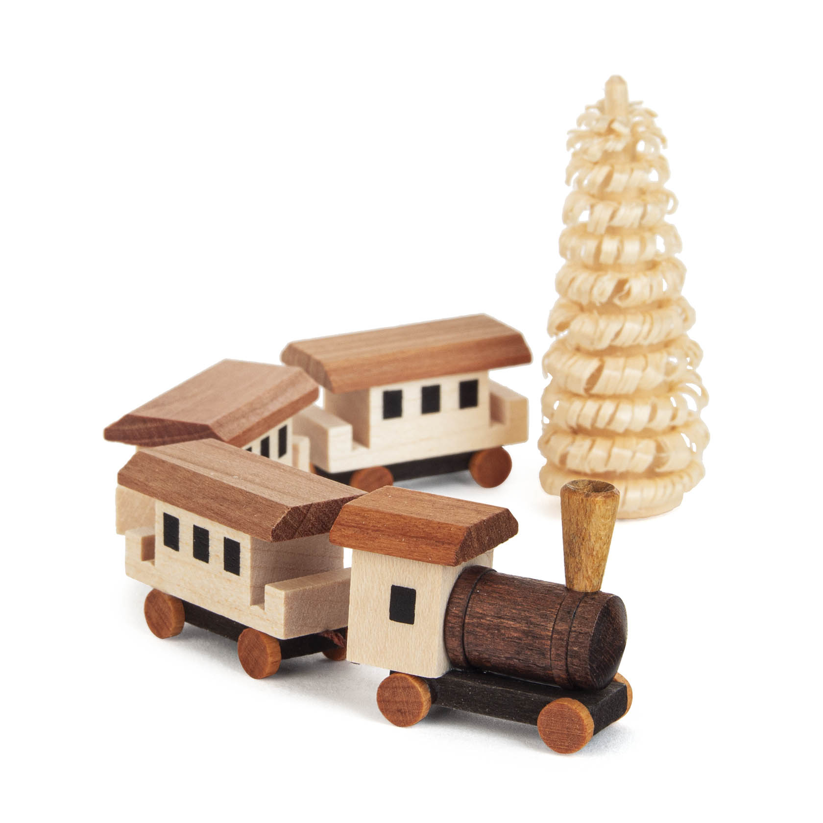 Holzspielzeugeisenbahn bestehend aus Lokomotive und zwei Wagen, neben einem spiralförmig geschnitzten Baum aus Holz.