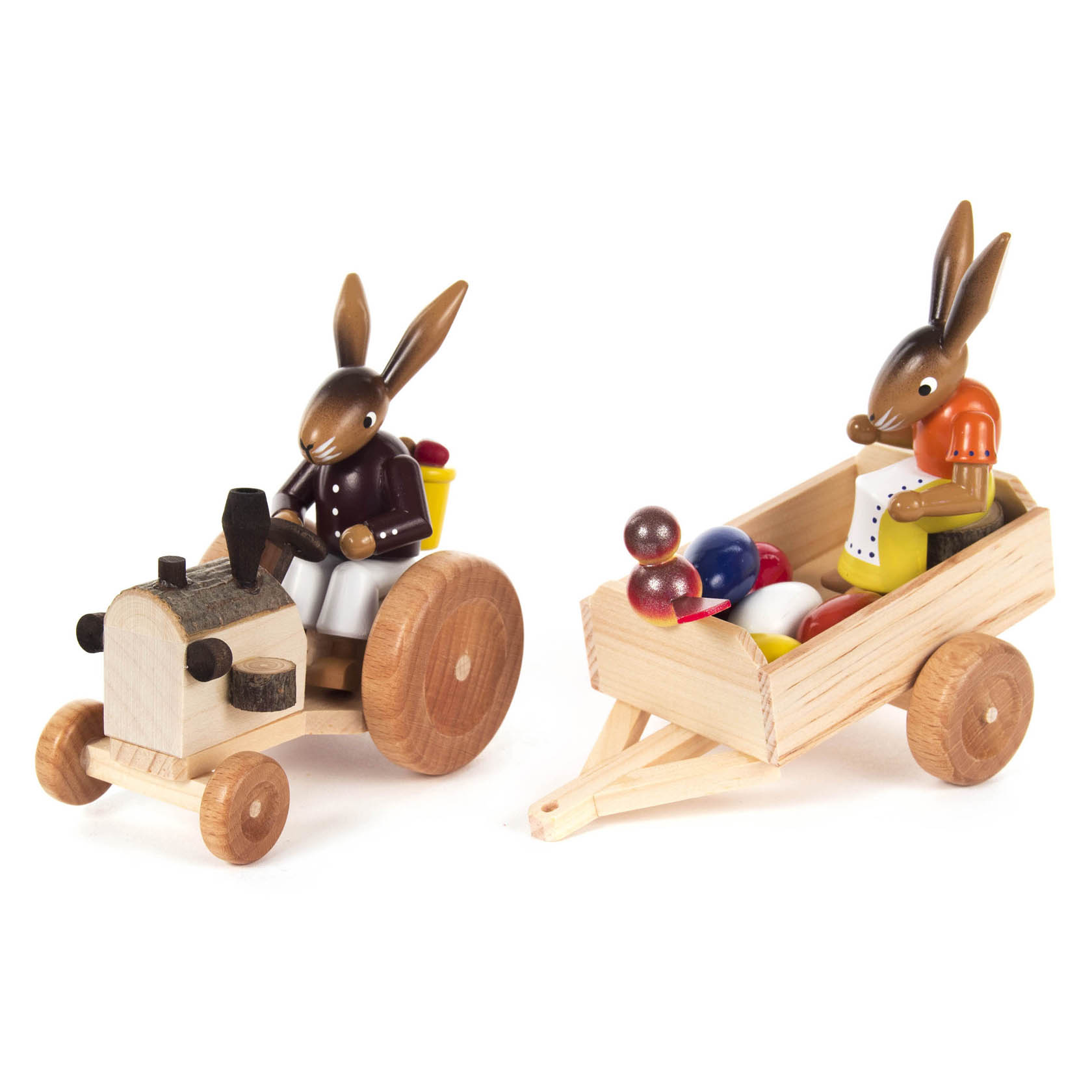 Wooden bunny figures; one is driving a small tractor, and the other sits in a trailer filled with colorful eggs.