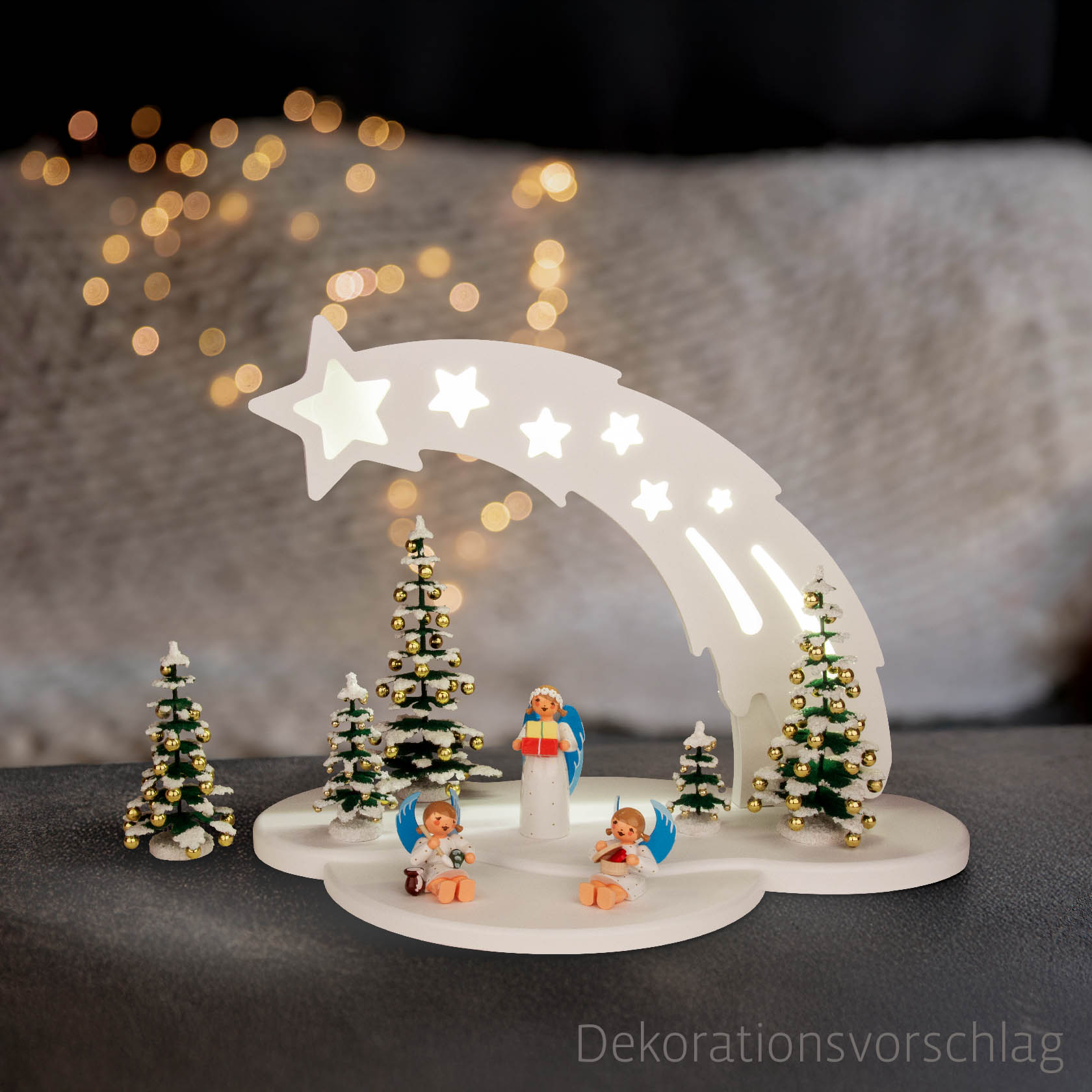 White arch with star design, featuring LED lights. Below, there are miniature angel figurines and small decorative Christmas trees.