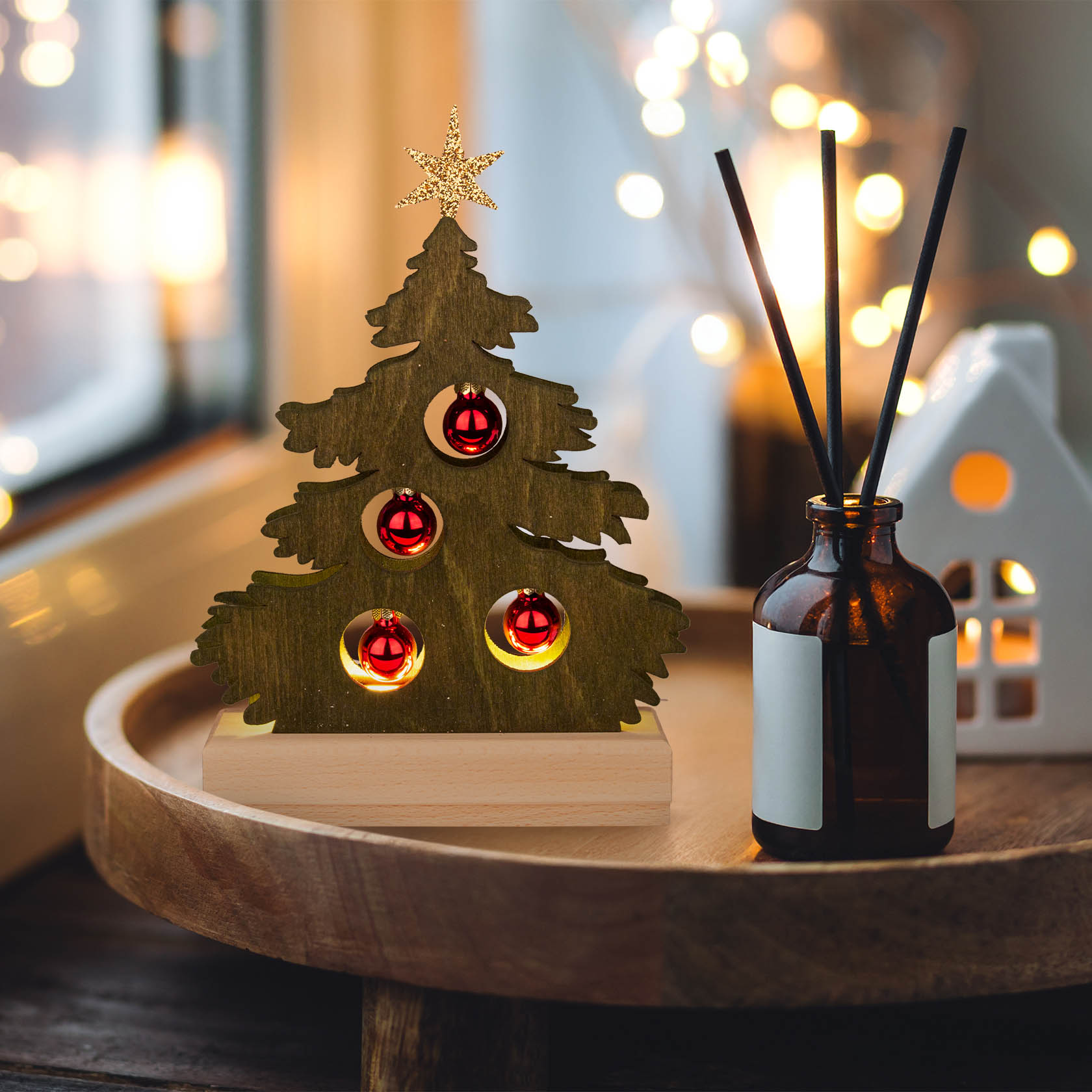 A small green-stained wooden Christmas tree with red baubles and LED strip lighting, connected via USB, placed on a wooden tray.