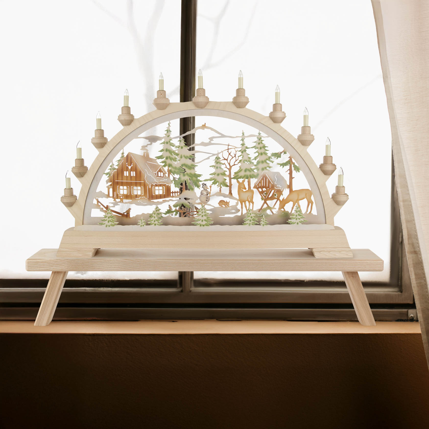 Ein farbig beleuchteter Schwibbogen mit einem Forsthaus-Motiv. Der Bogen zeigt ein winterliches Waldhaus, Tiere und Figuren, beleuchtet mit elektrischen Kerzen.
