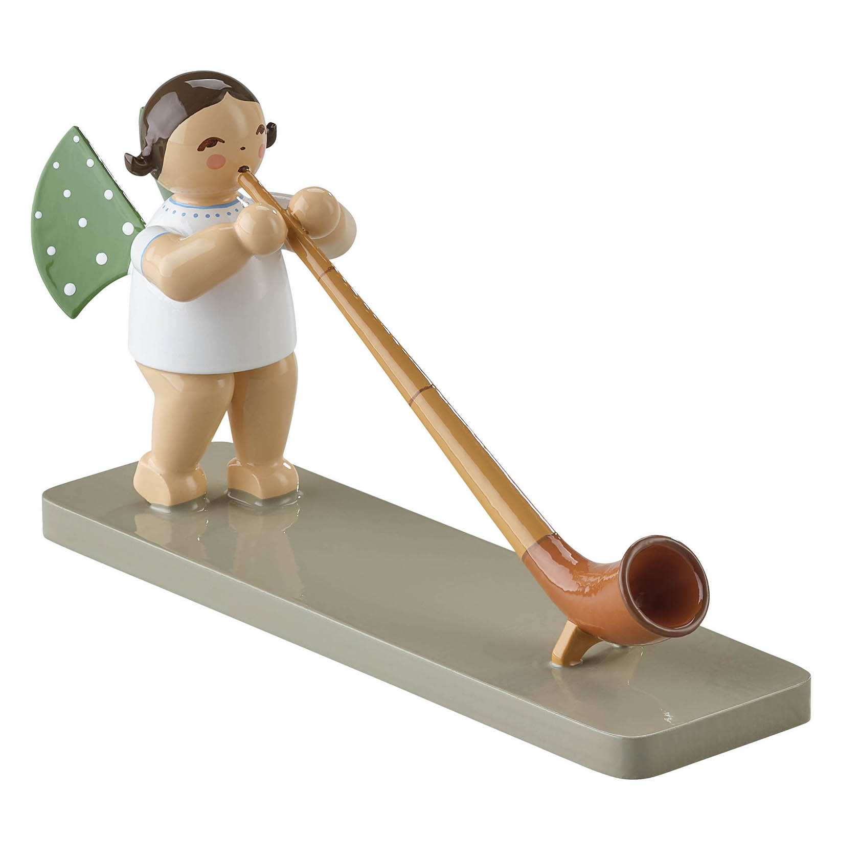 Ein Holzengel mit grünen Flügeln und weißen Punkten spielt ein langes, braunes Alphorn auf einem hellgrünen Sockel. im Dregeno Online Shop günstig kaufen