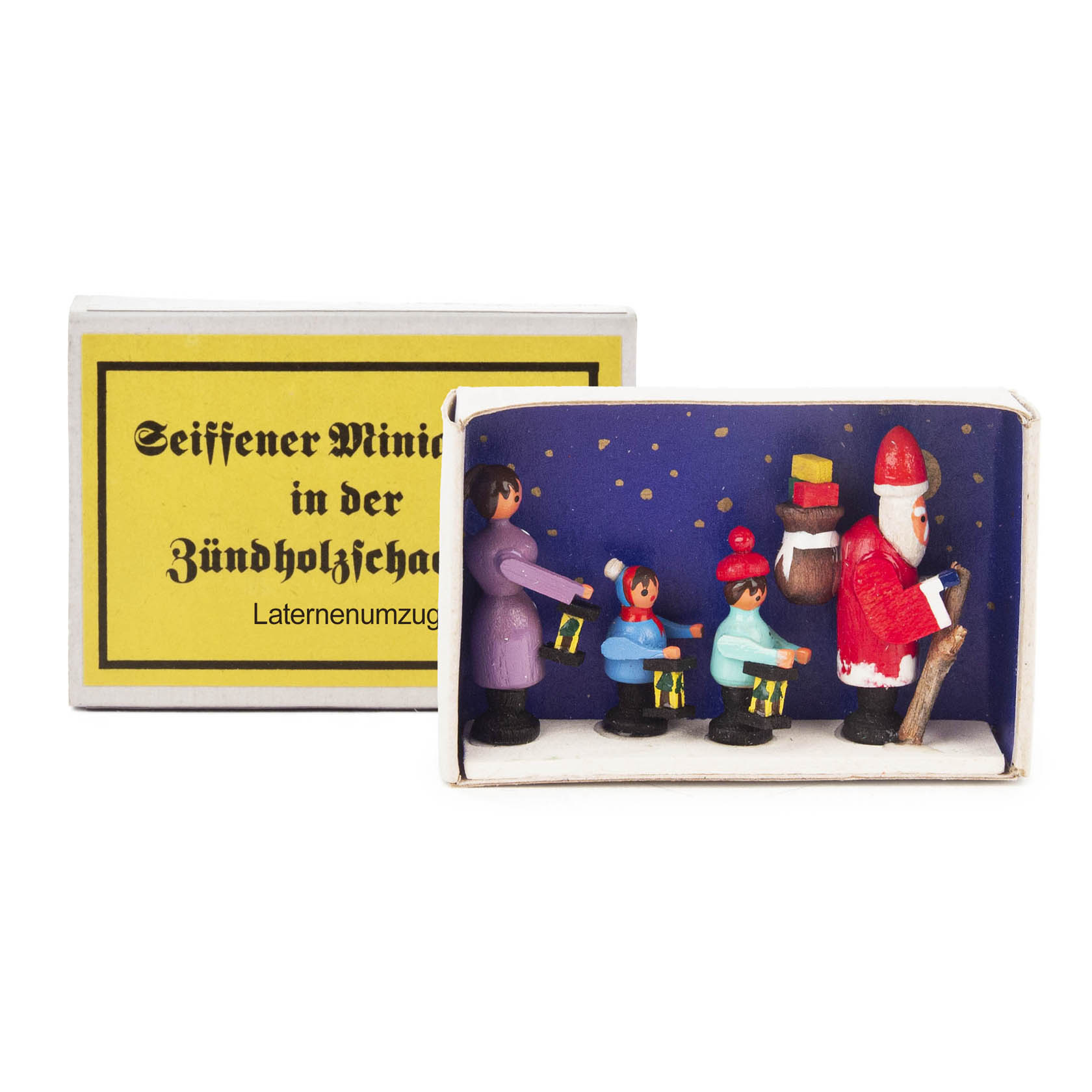 A miniature scene in a matchbox depicting four wooden figures, including Santa Claus and a group of three children holding lanterns, representing a lantern procession. im Dregeno Online Shop günstig kaufen