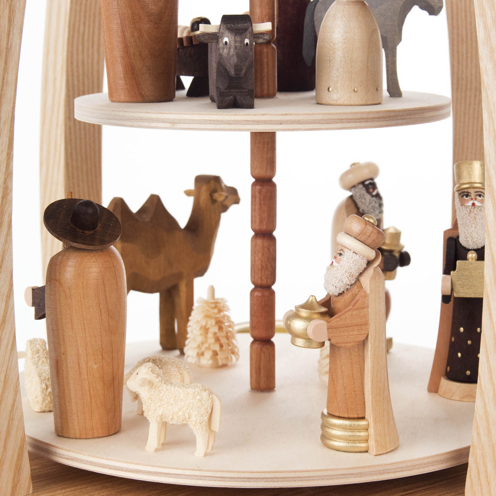 A two-tiered pyramid featuring nativity scene figurines made of wood, including camels, wise men, and a shepherd with a sheep. Designed for tealights.
