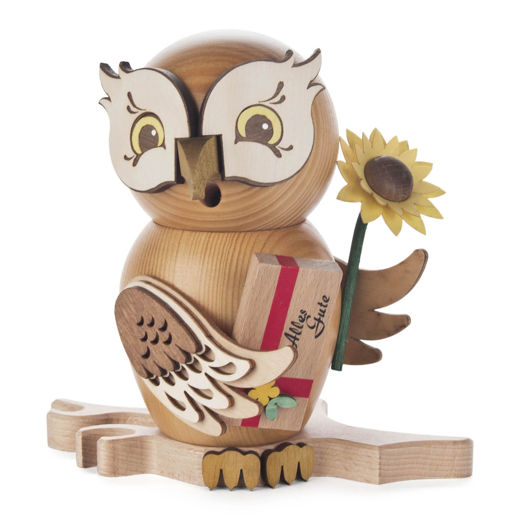 Holzfigur einer Eule mit großen Augen und einem aufgesetzten Schnabel. Die Eule hält eine Sonnenblume und ein Geschenk mit der Aufschrift 'Alles Gute' in den Flügeln. im Dregeno Online Shop günstig kaufen