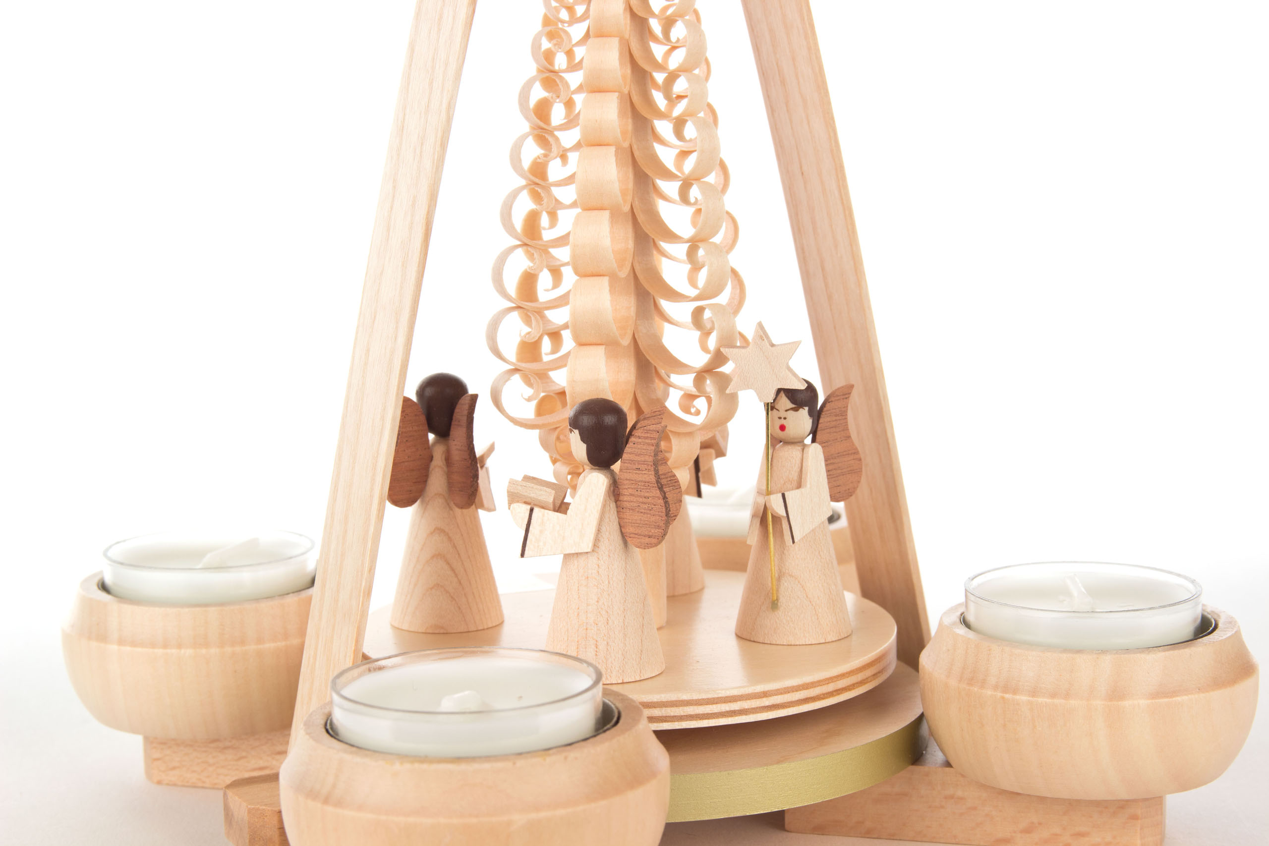 A wooden pyramid with three angel figurines, holding a book and a star, surrounded by four tealight candle holders.