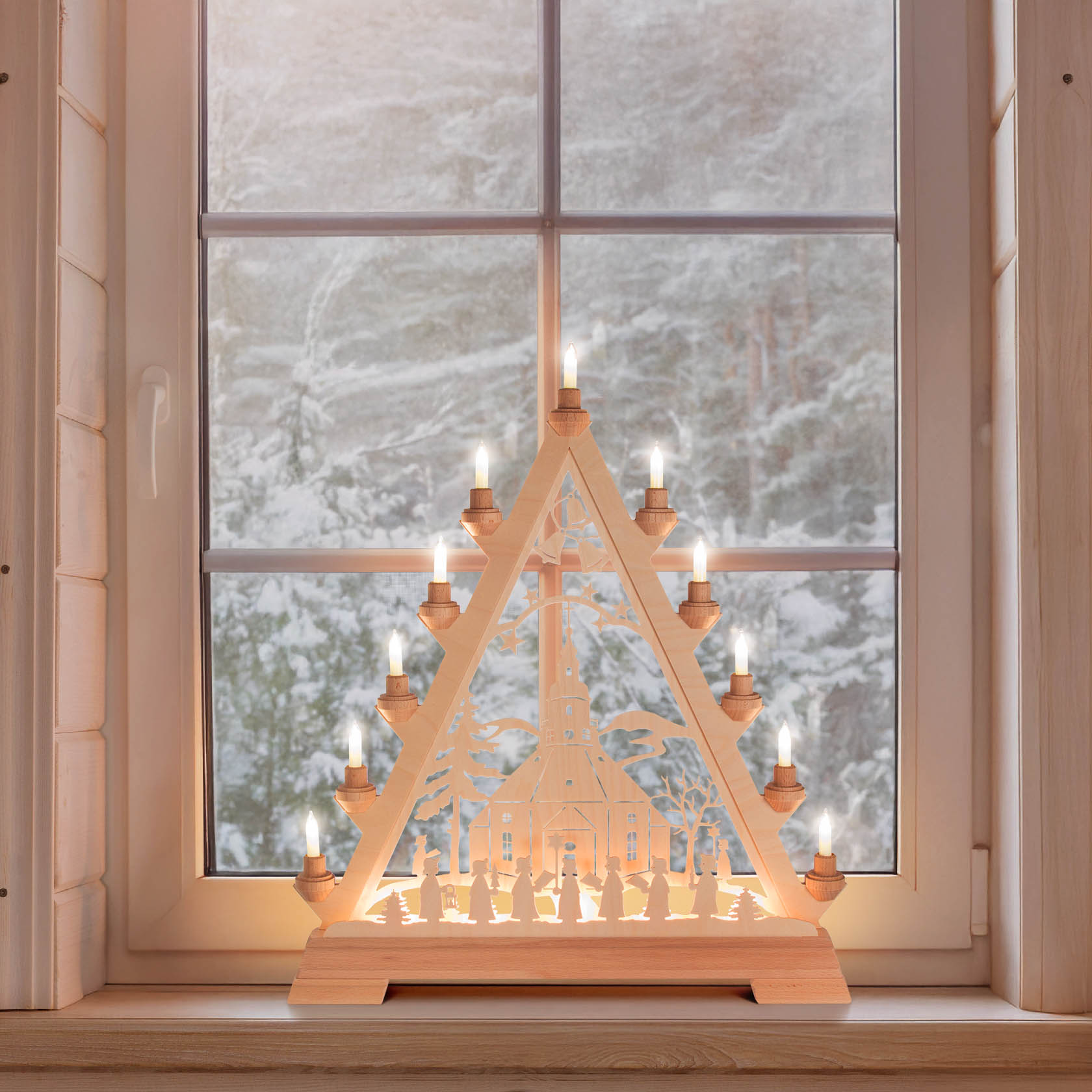 Illuminated wooden Christmas pyramid with Seiffen Church and Kurrende figurines on a windowsill.