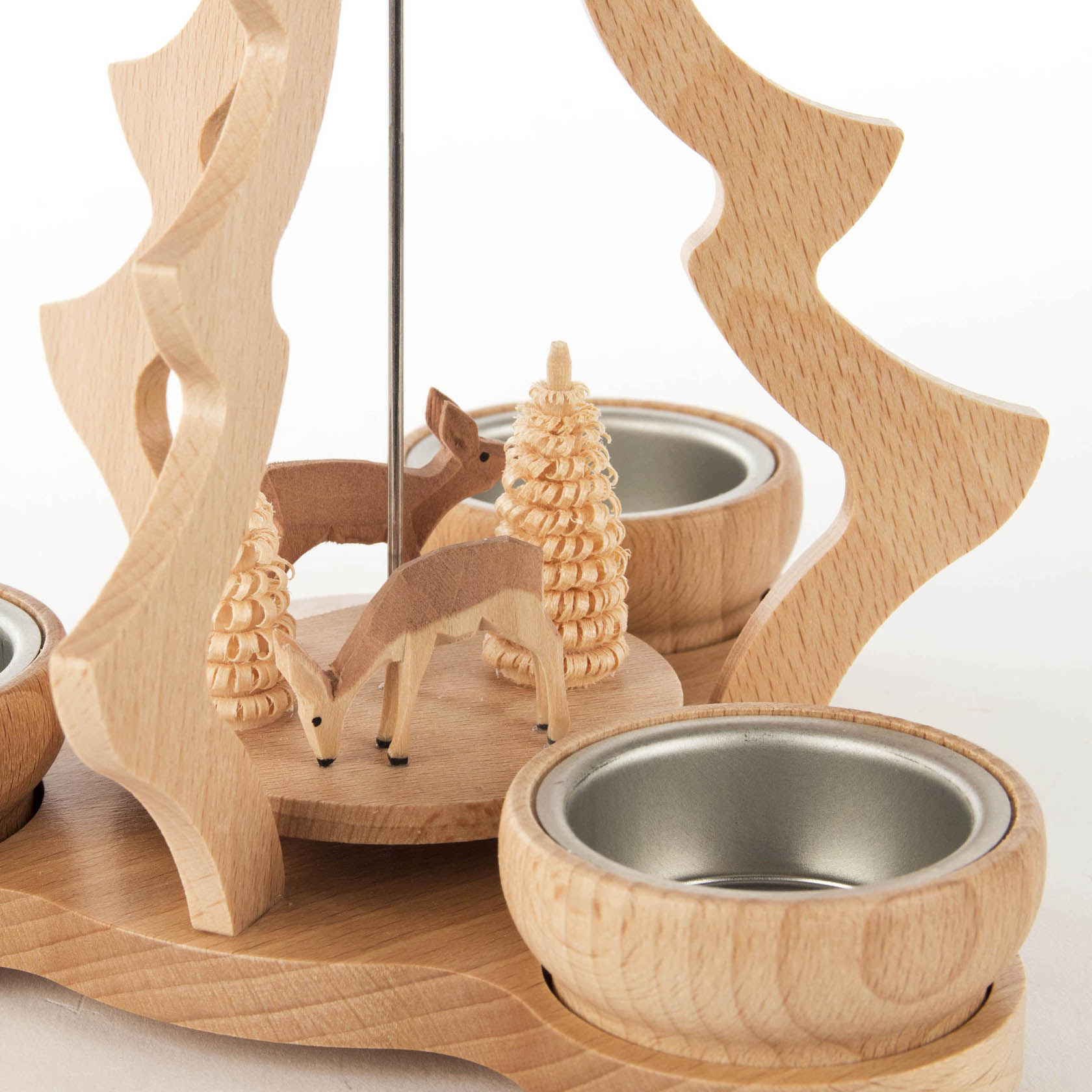 Holzpyramide mit zwei Rehen und zwei Teelichthaltern. Die Rehe stehen auf einer runden Plattform mit dekorativem Baum.