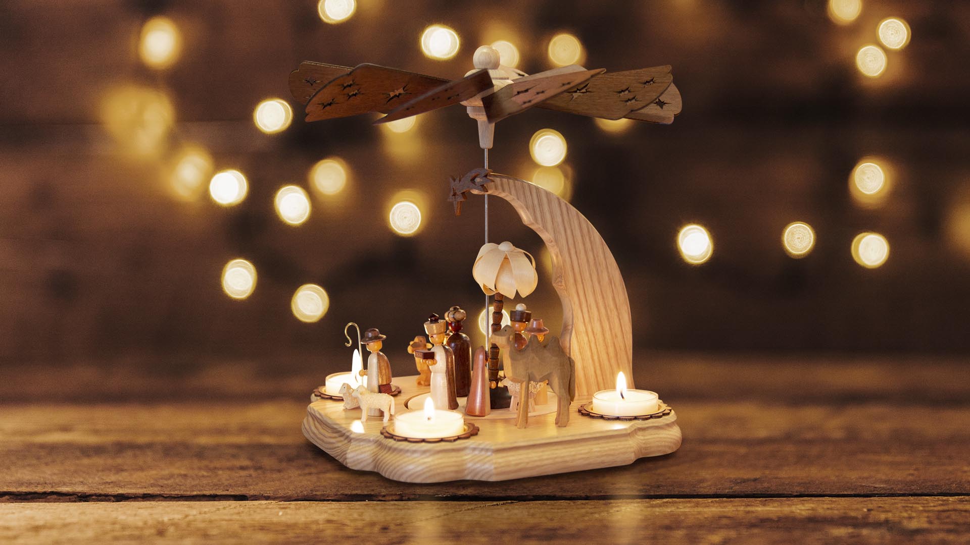 Weihnachtspyramide mit Krippenfiguren und brennenden Kerzen