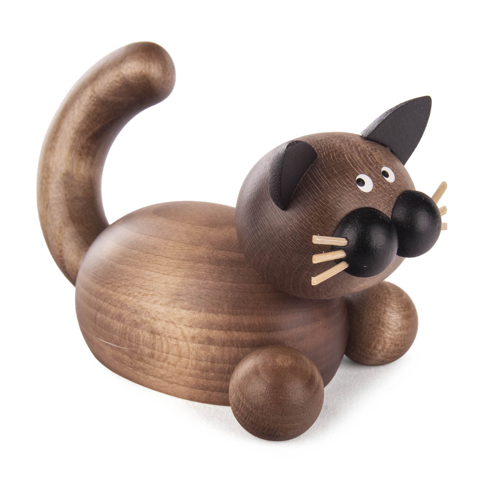 Holzfigur einer liegenden Katze mit rundem Körper, großen Augen und aufrechtem Schwanz. Die Katze ist braun mit dunkelgrauen Details.