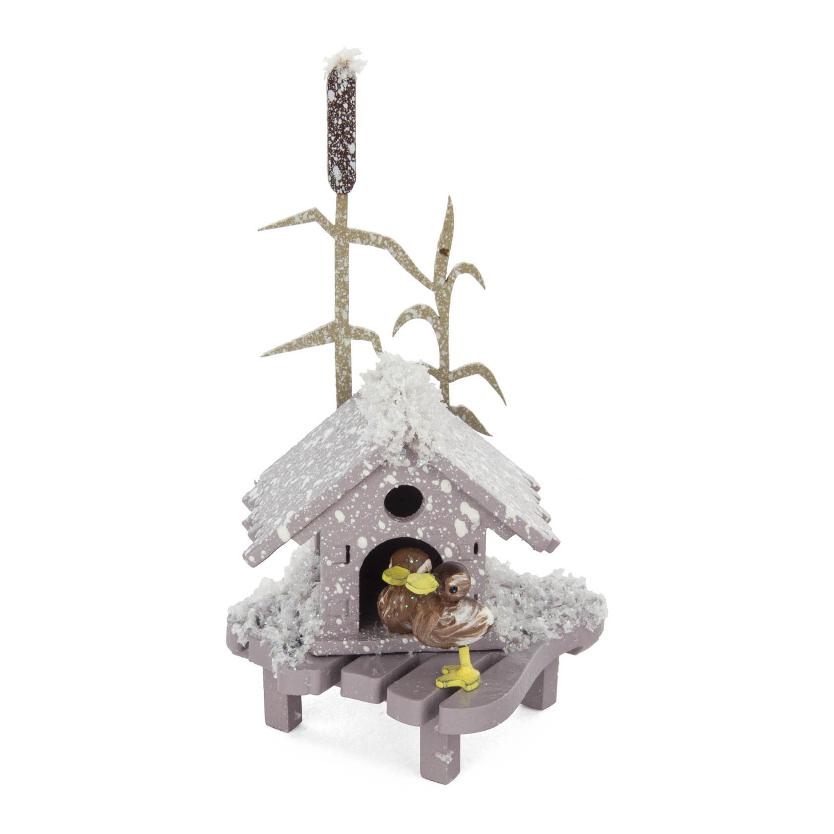 Ein kleines, verschneites Holz-Entenhaus mit zwei Enten darin. Nebenzweig und Schilfrohr im Hintergrund. im Dregeno Online Shop günstig kaufen