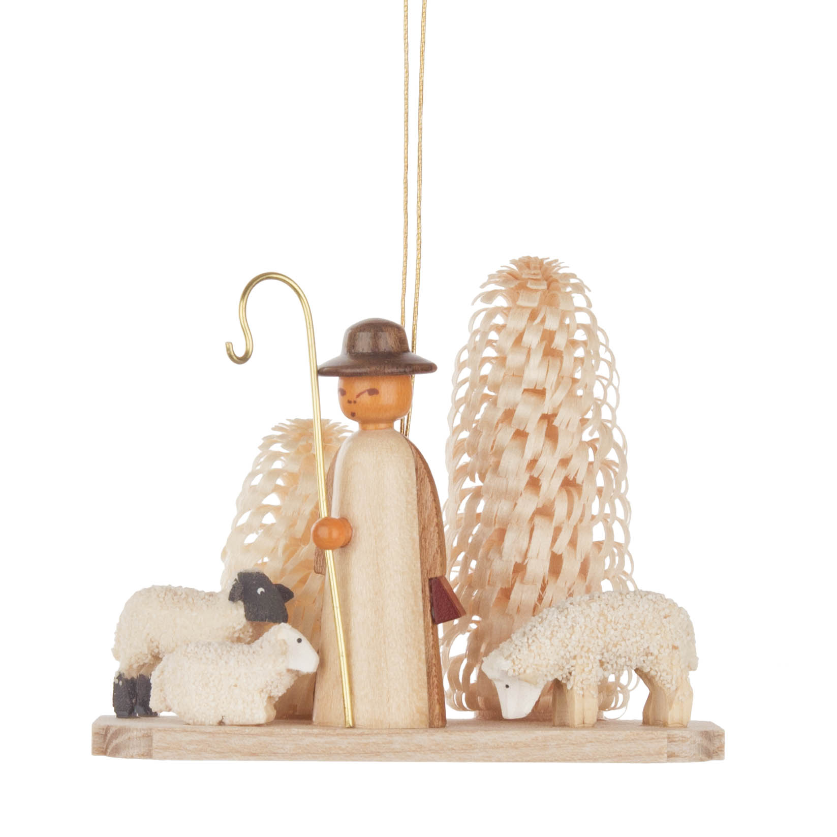 Ein Holz-Ornament mit einem Schäfer in einem braunen Umhang und Hut, der einen goldenen Haken hält, steht zwischen zwei Schafen. Im Hintergrund sind zwei verzierte Bäume. im Dregeno Online Shop günstig kaufen