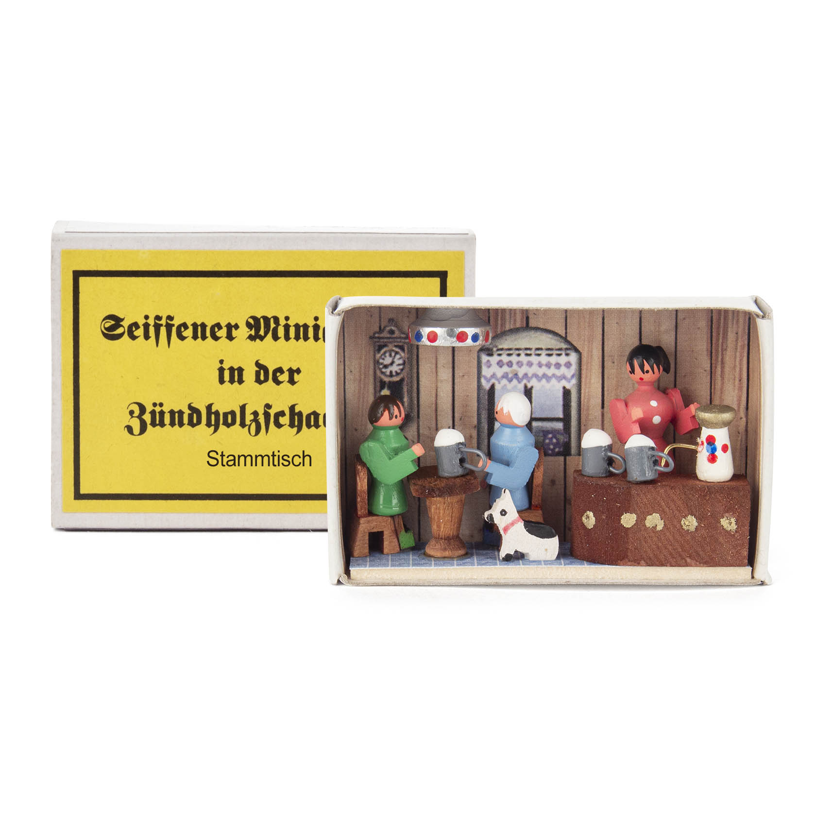 Miniature wooden figures in a matchbox representing a cozy pub scene with three people at a table, mugs, beer barrel, dog, and a clock on the wall. im Dregeno Online Shop günstig kaufen