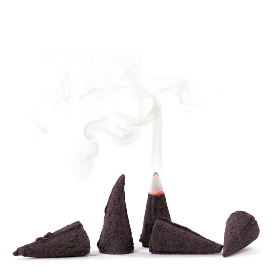 Five brown incense cones, four standing and one on its side, with smoke rising from a lit cone.