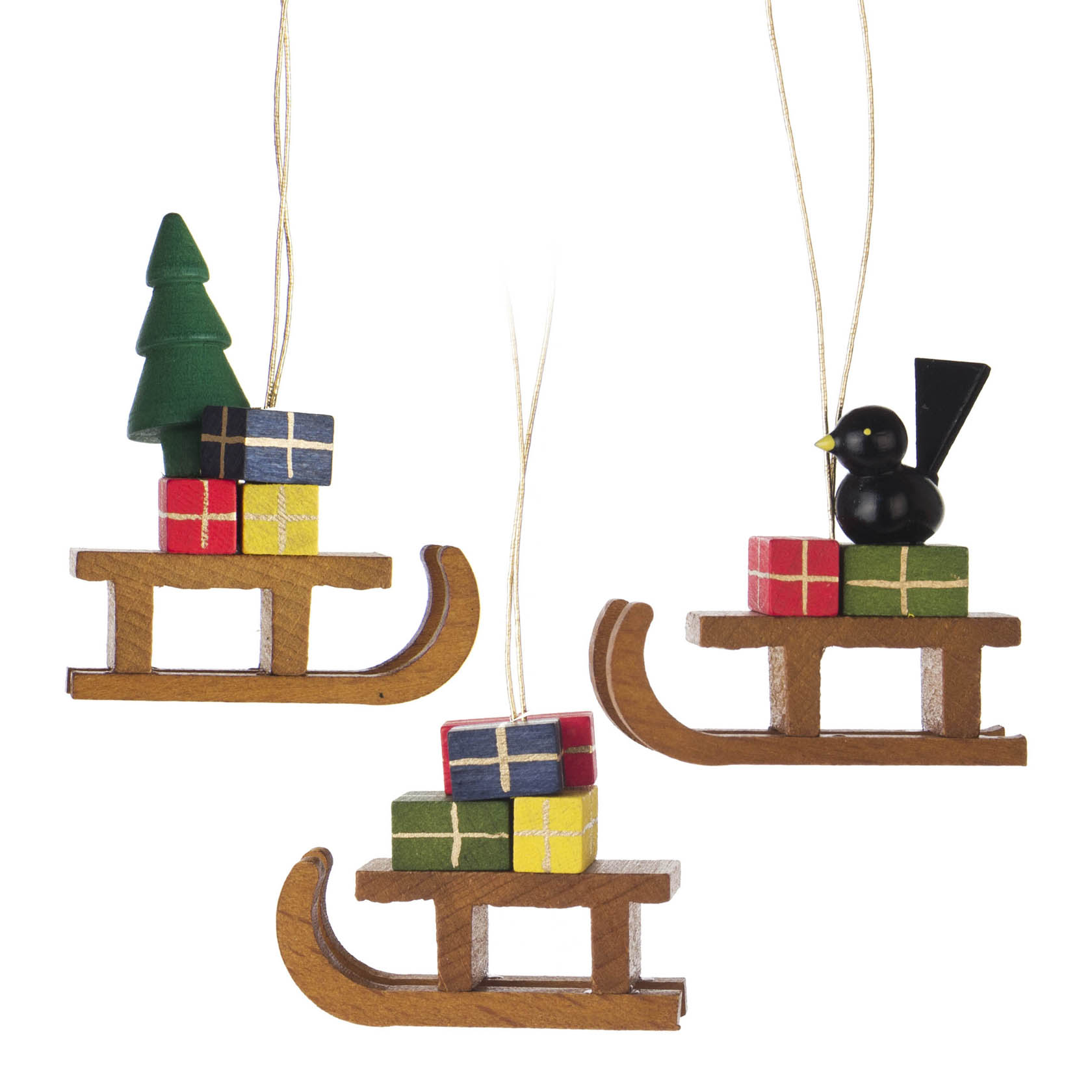 Three wooden sled ornaments, each carrying Christmas-themed decorations like a tree or gifts and one with a black bird.