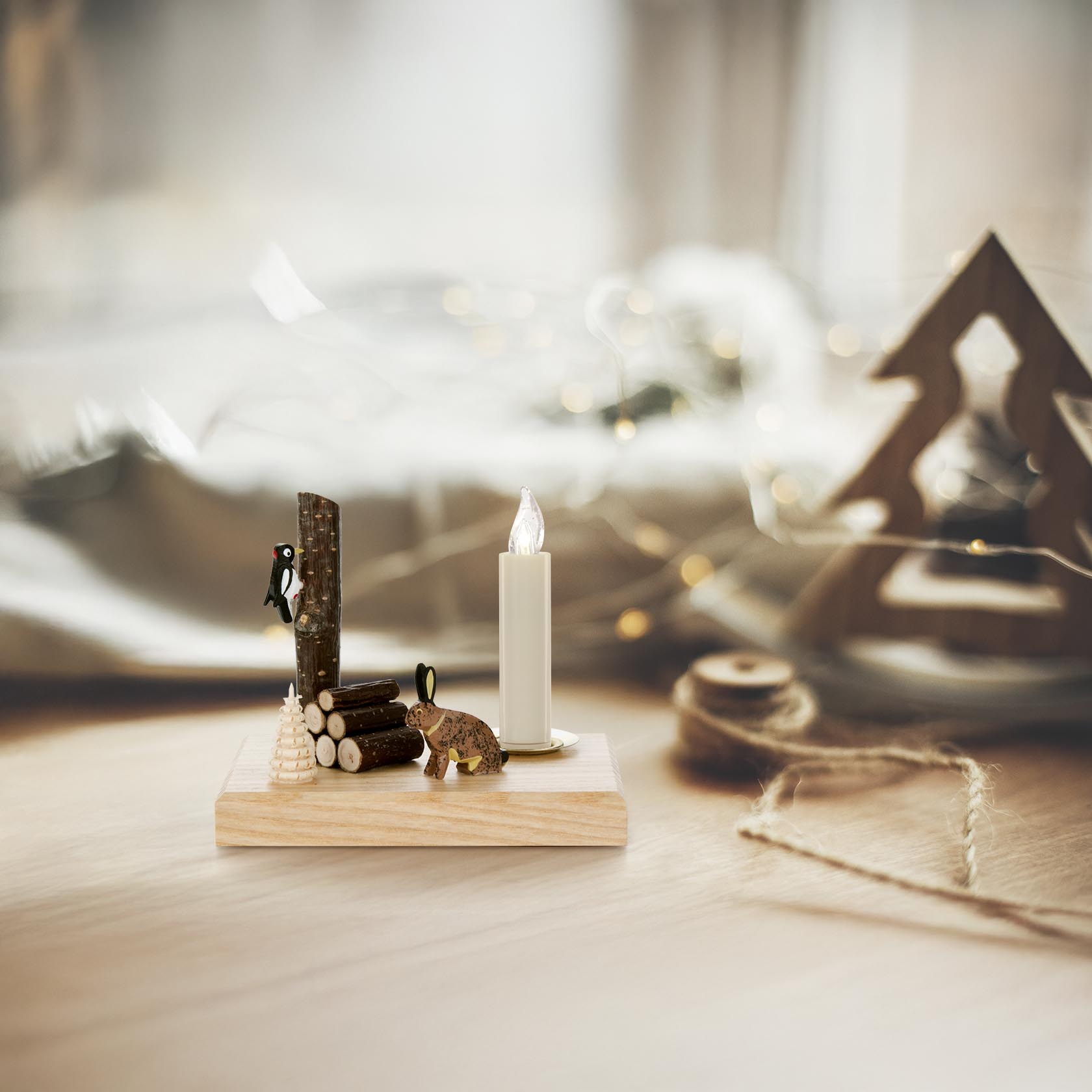 Wooden candle holder featuring a small carved hare and a woodpecker on a log, designed for a 14mm candle.