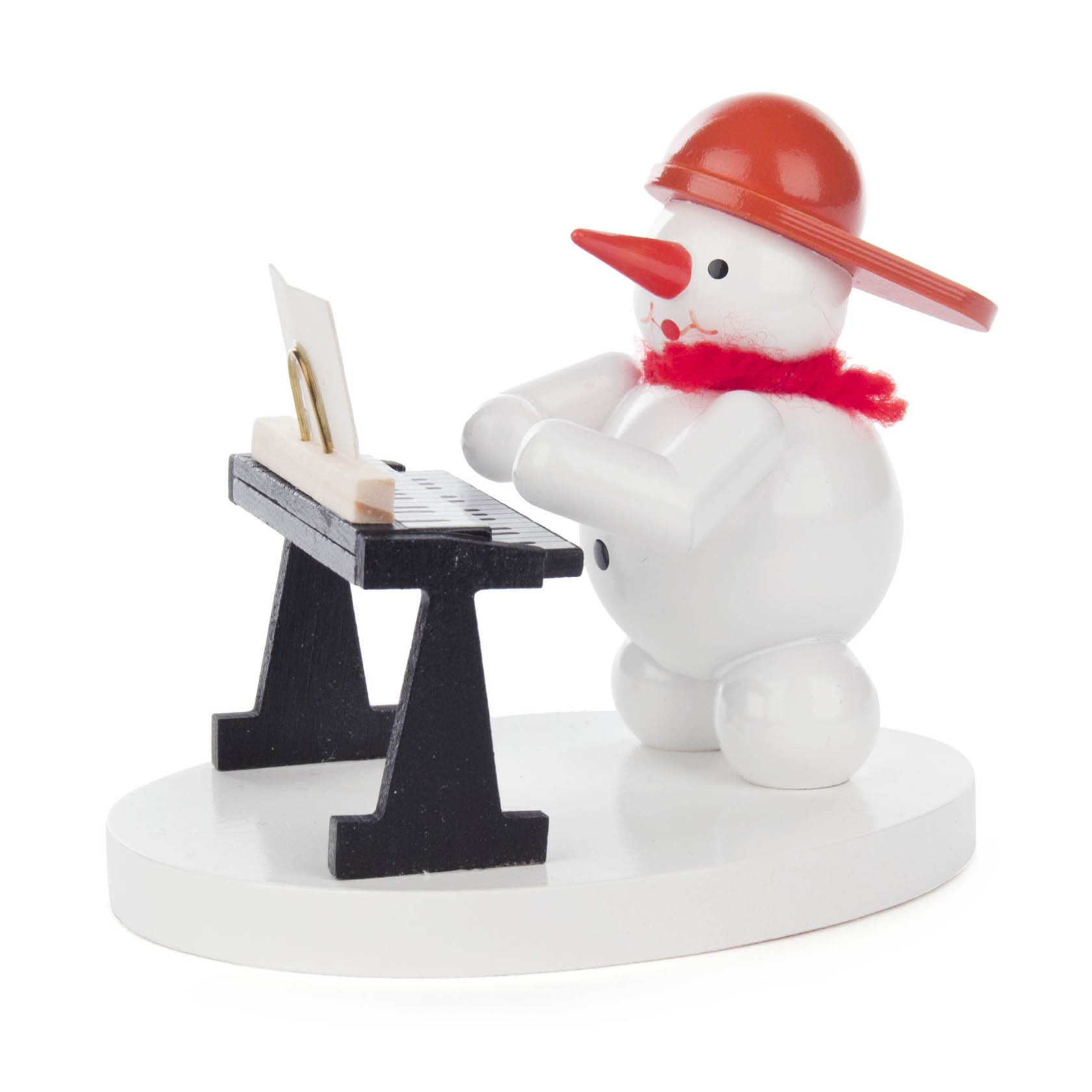 Kleiner Schneemann aus Holz, spielt auf einem schwarzen Keyboard, trägt roten Schal und orange Hut. im Dregeno Online Shop günstig kaufen