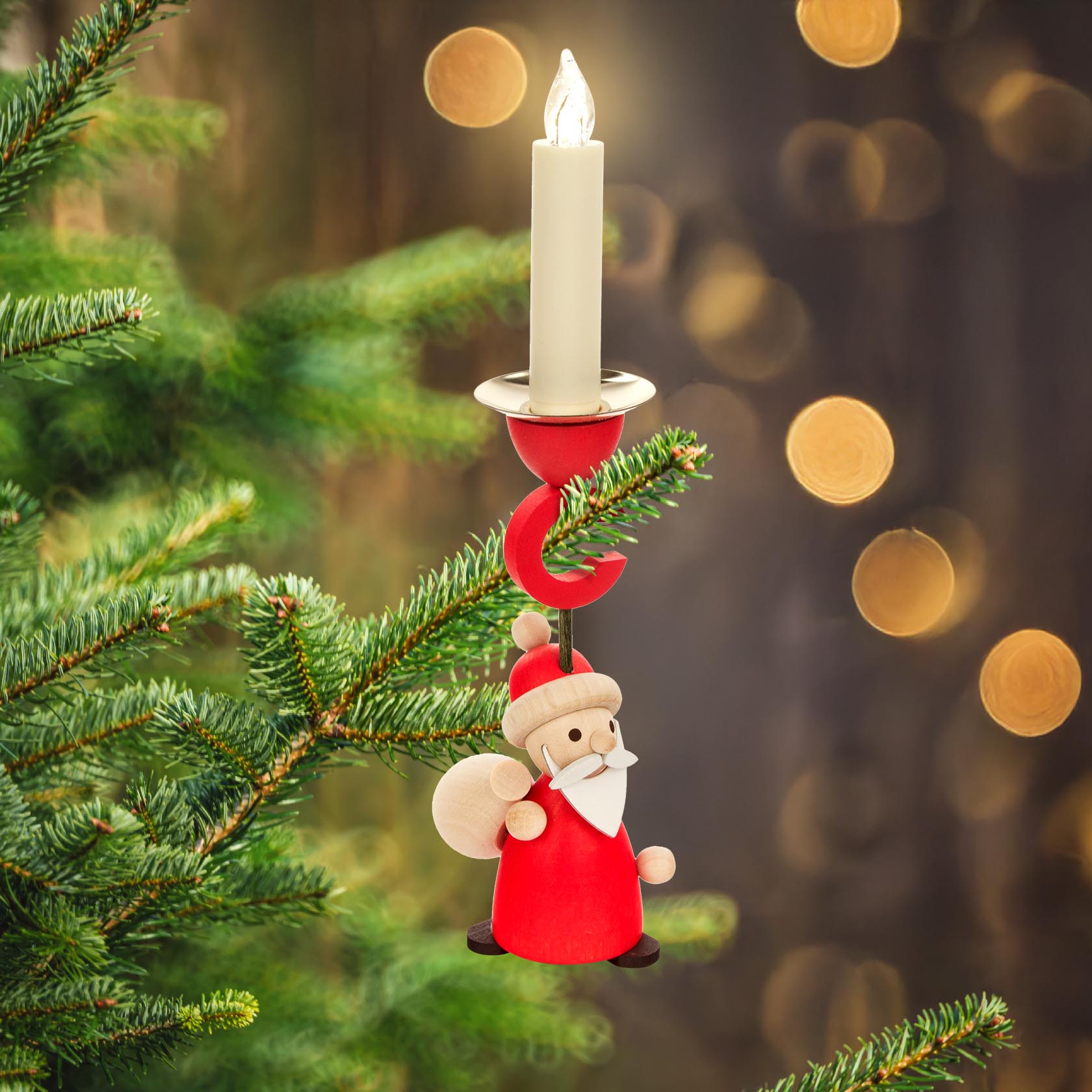 Ein Weihnachtsbaumzweig mit einem Kerzenhalter in Form eines Ruprecht mit rotem Gewand und einem Sack, der eine Kerze mit 14mm Durchmesser hält.