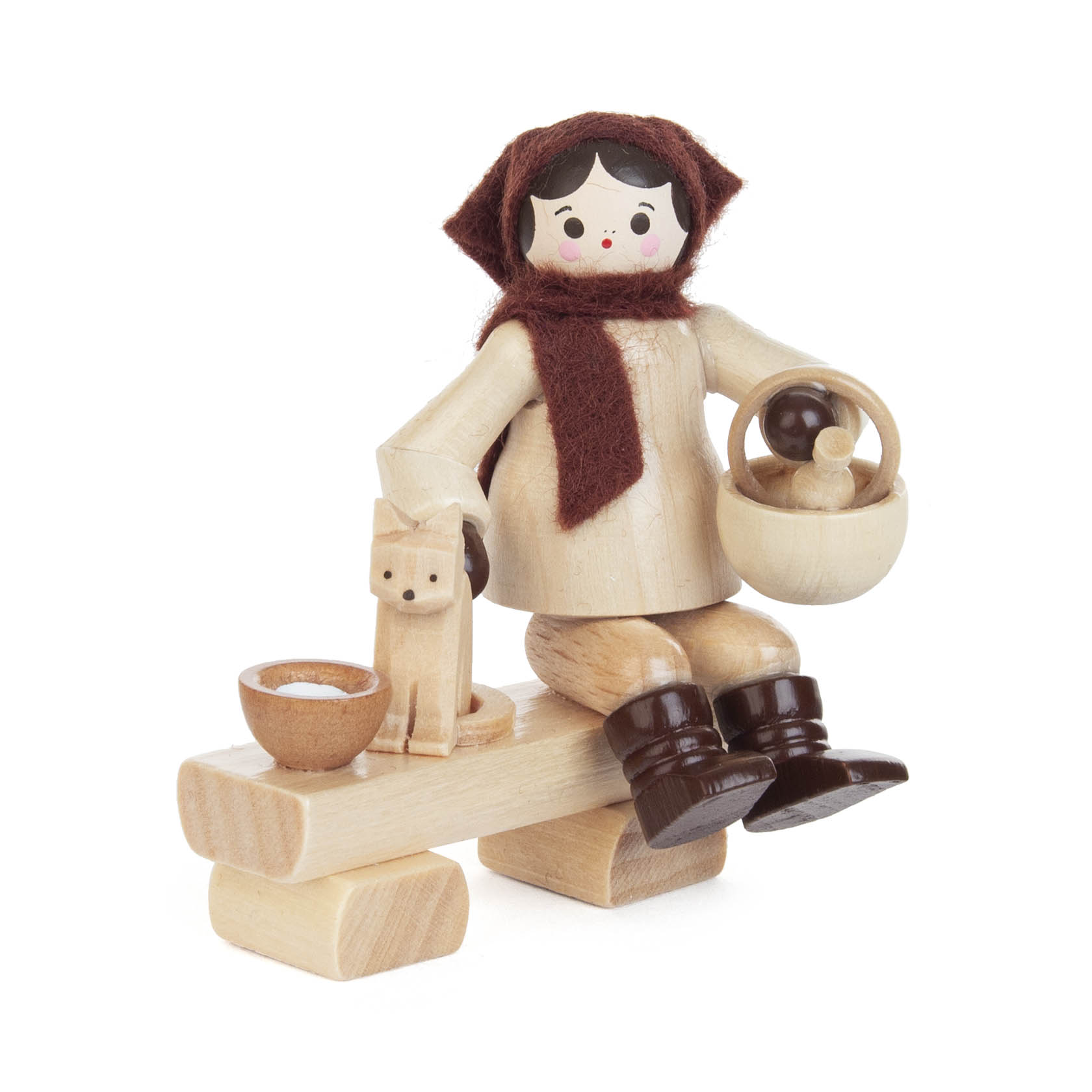 Holzfigur eines Mädchens mit braunem Schal und Kleid sitzt auf einem Holzbalken, hält einen Korb und füttert eine kleine Holzkatze aus einer Schale.