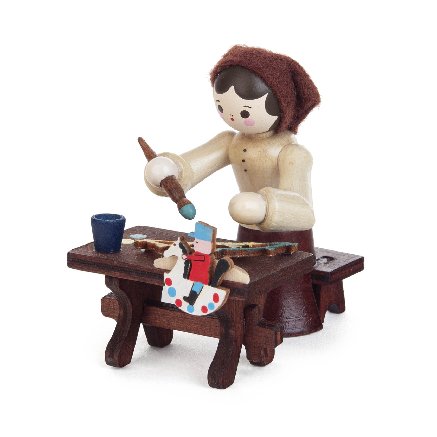 Holzfigur einer Schwibbogenmalerin in traditioneller Kleidung, die an einem Tisch sitzt und mit einem Pinsel einen bemalten Holzbogenschmuck dekoriert. im Dregeno Online Shop günstig kaufen