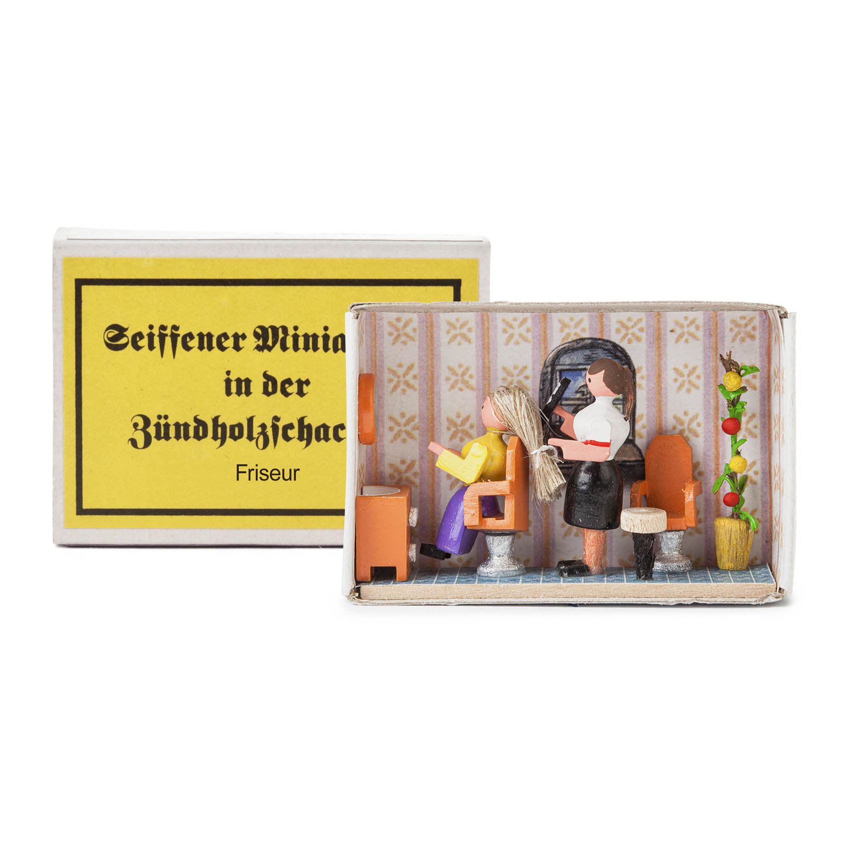 A miniature scene in a matchbox showing a hairdresser cutting a client's hair. The scene includes tiny furniture and decorations. im Dregeno Online Shop günstig kaufen