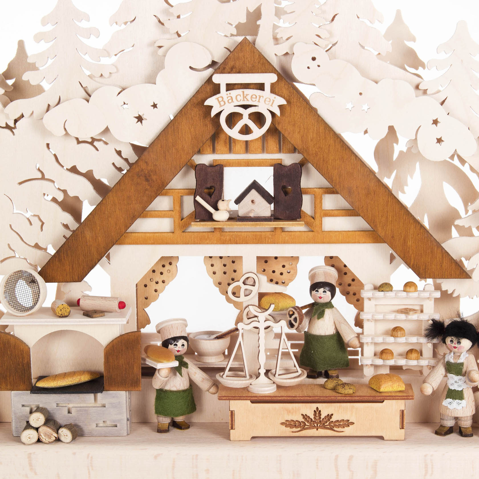 Small illuminated wooden arch depicting a bakery scene with bakers, bread, and baking tools, featuring warm indirect electric lighting.