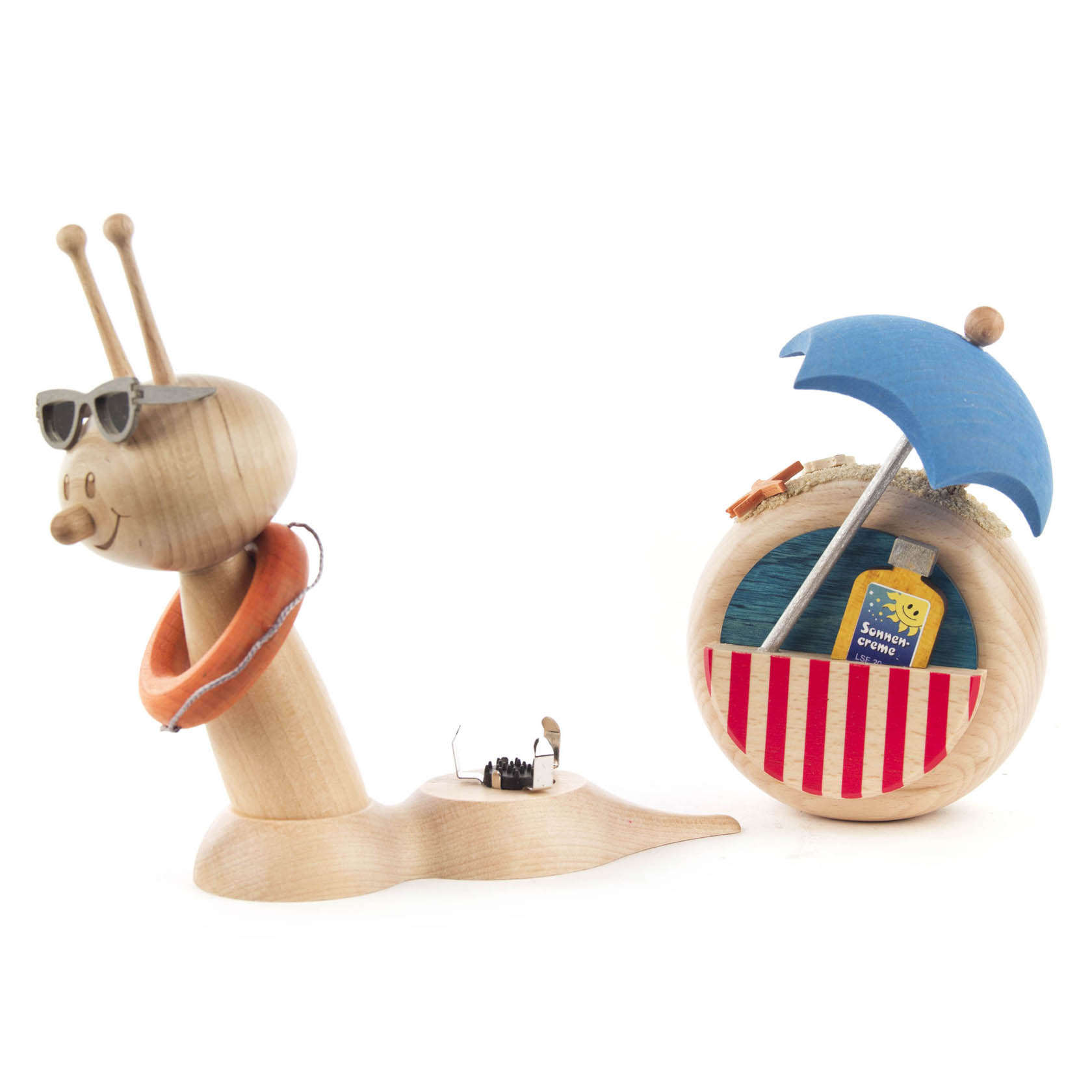 Holzfigur einer lächelnden Schnecke mit Sonnenbrille und Schwimmring, aus der Schale kommt Räucherrauch. In der Schale befindet sich ein Schirm und ein Buch.