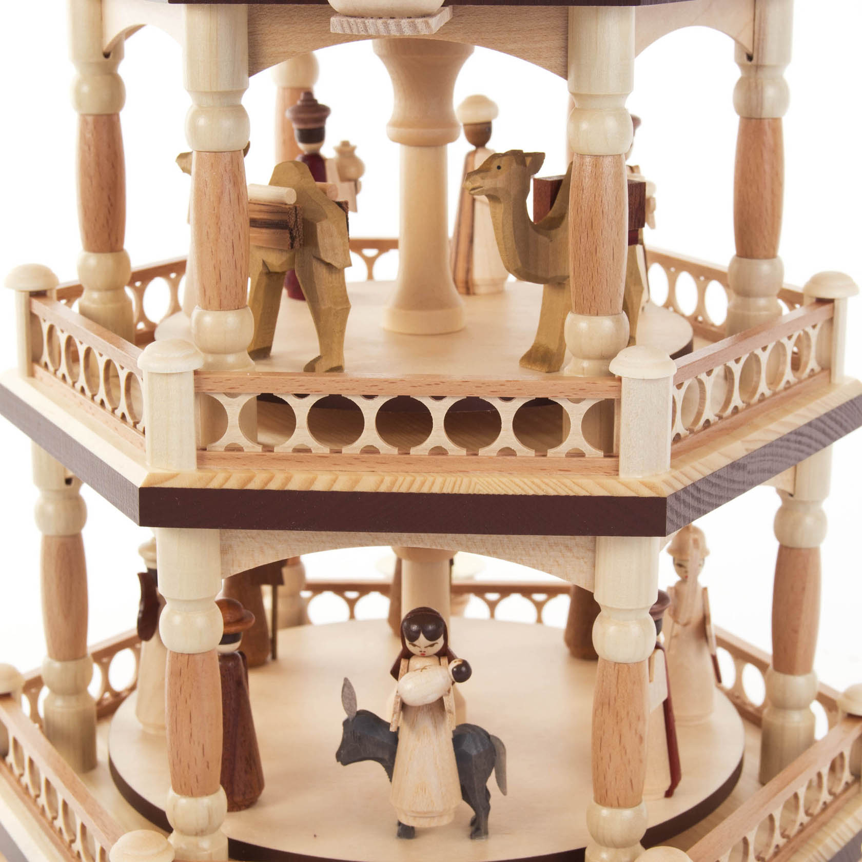 Four-tiered wooden pyramid with nativity scene featuring the birth of Christ. Camels and figures are displayed on the upper levels.