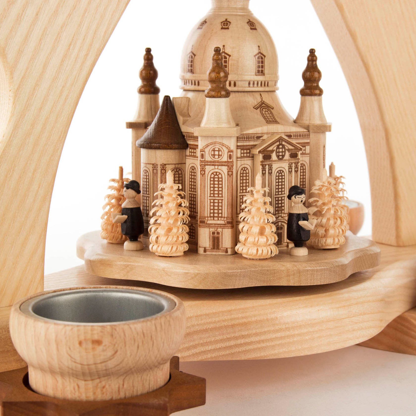 Holzpyramide für Teelichter mit Miniatur der Dresdner Frauenkirche, umgeben von Holzfiguren und Tannenbäumen.